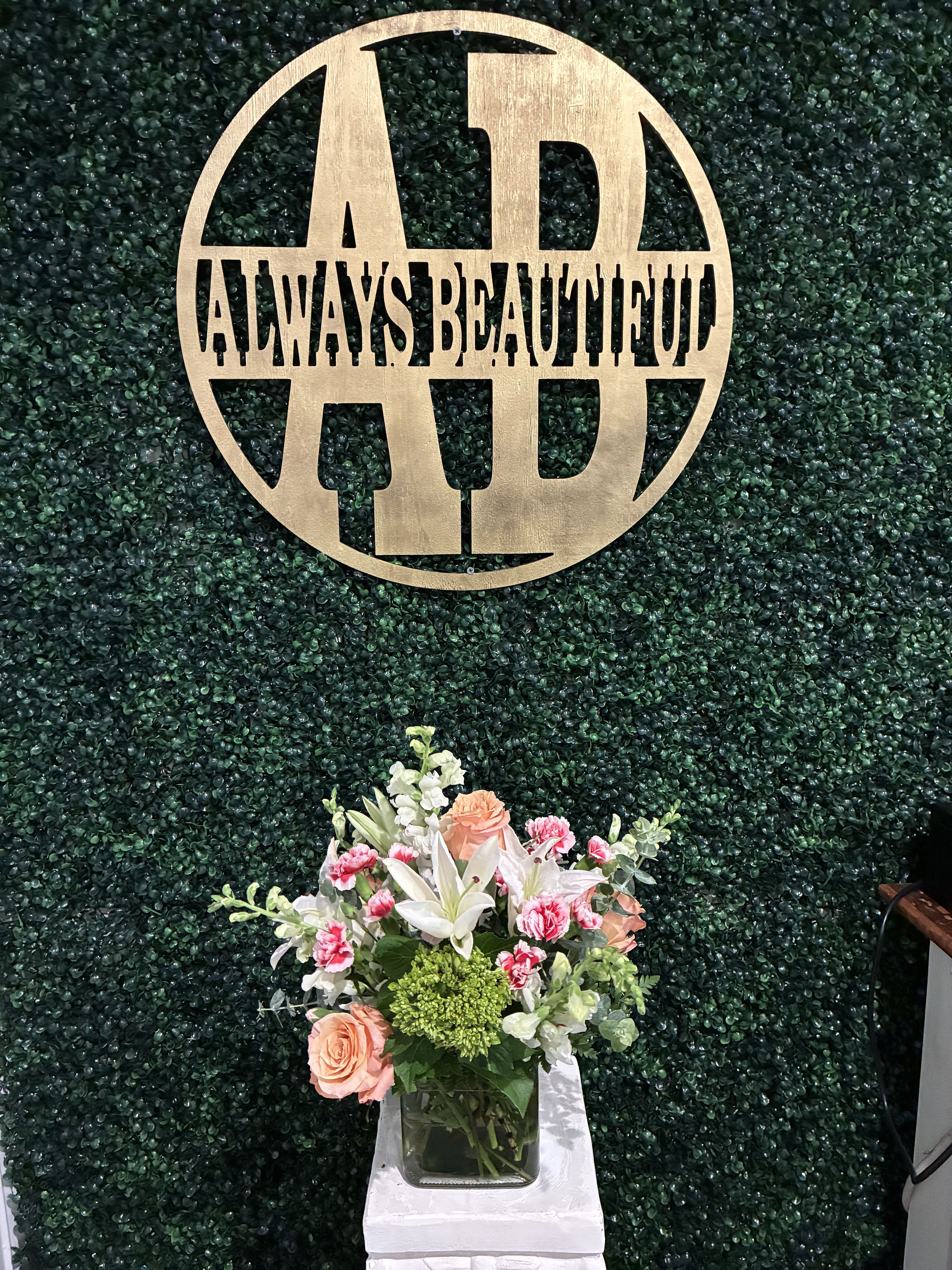 Mixed floral arrangement in a glass vase with peach roses and white lilies