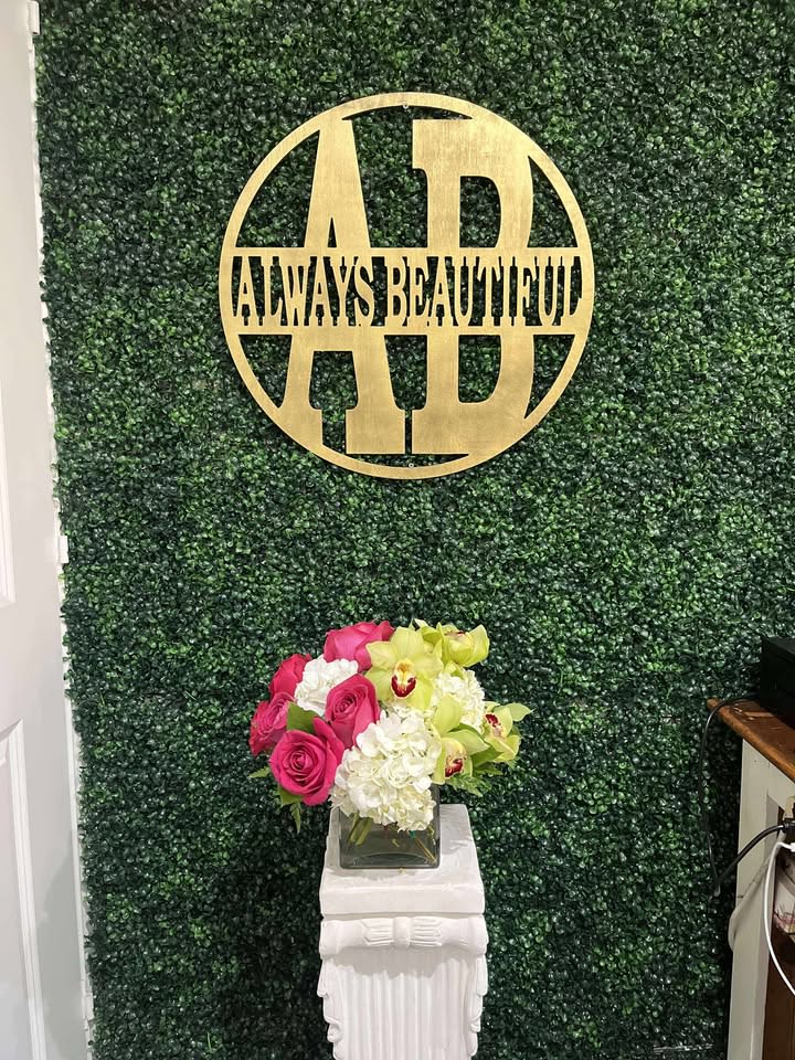 Pink roses and white flowers in a square glass vase on a pedestal
