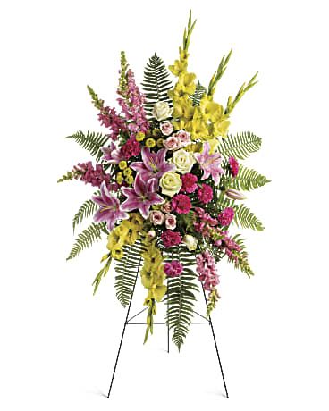 Standing floral spray with pink, yellow, and white flowers on an easel