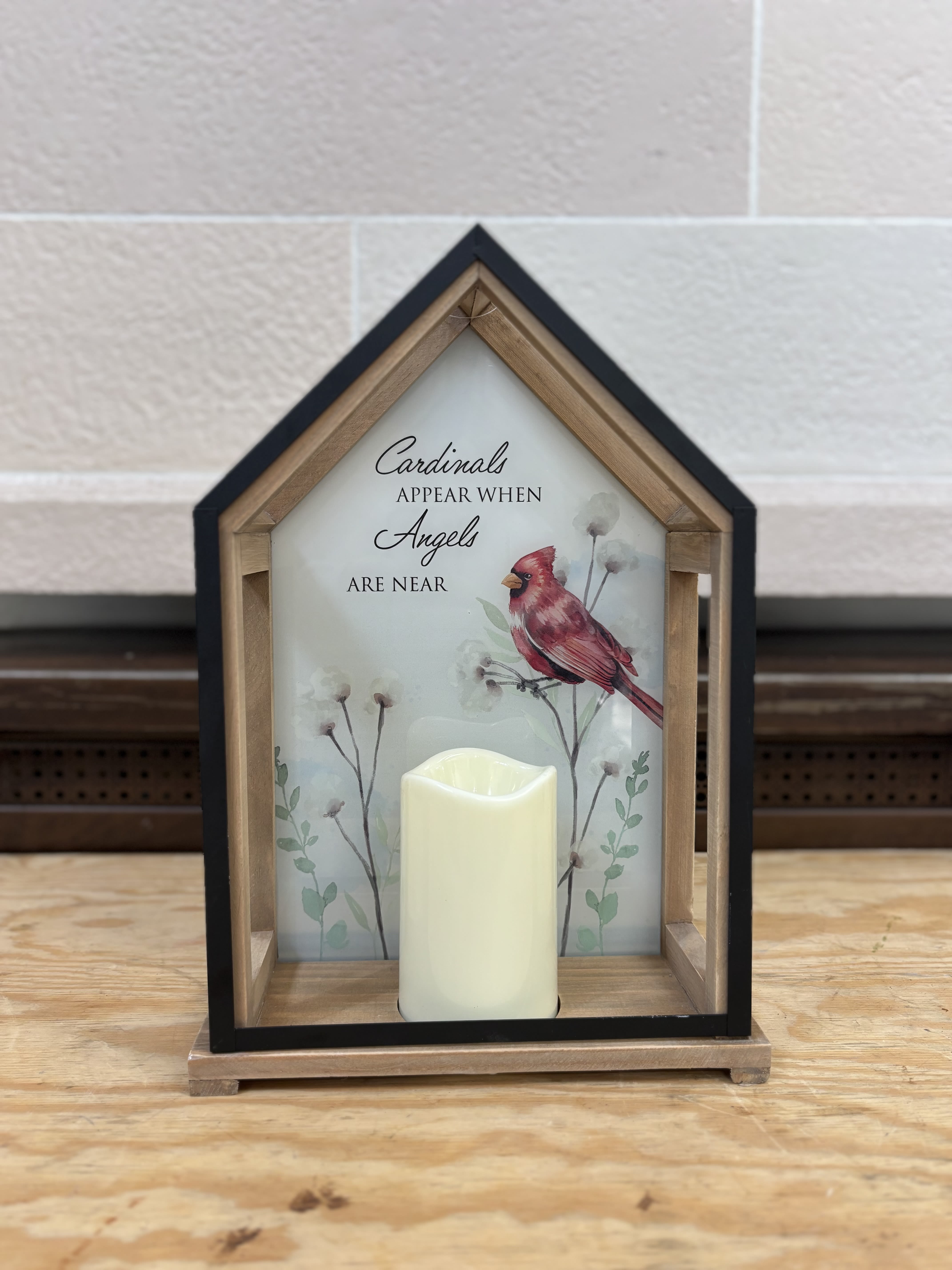 House-shaped memorial sign with a cardinal and a candle