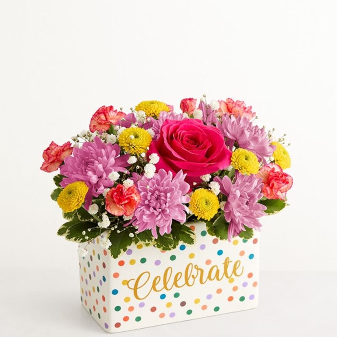 Mixed pink and yellow flowers in a polka-dot box with "Celebrate" text