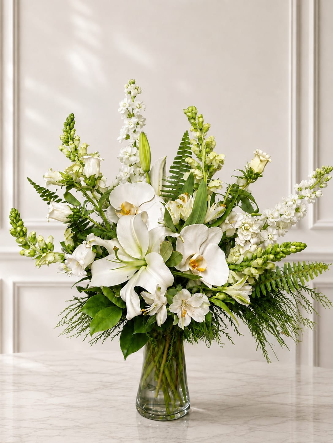 White orchids and lilies arranged in a clear glass vase