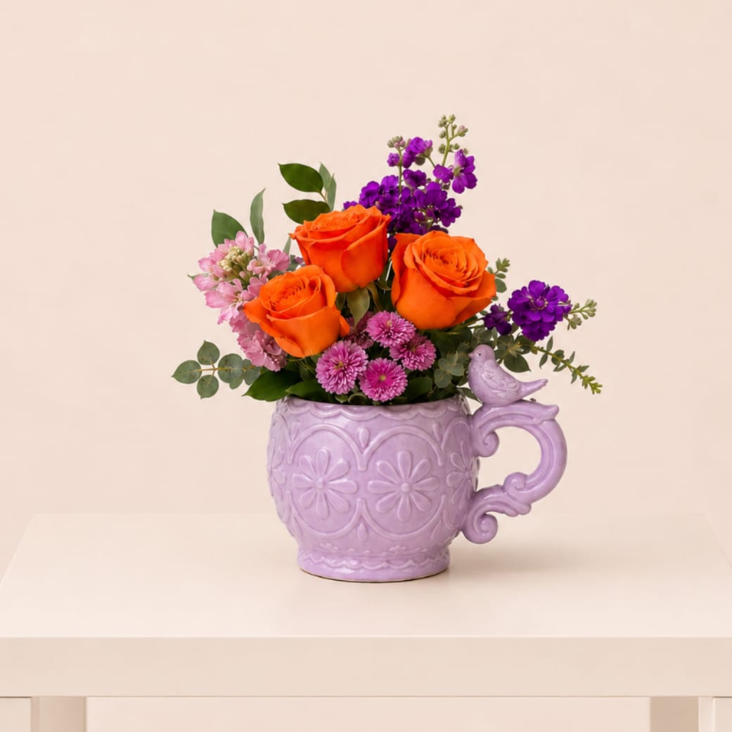 Garden Bird Bouquet - A cheerful, garden-inspired flower arrangement designed in a charming lavender mug with a delicate bird accent. Bright seasonal blooms and fresh greenery come together to create a joyful, vibrant design that brings a fresh and uplifting touch to any space.  Perfect for spring celebrations, birthdays, thank you gestures, get well wishes, or sending a sweet and thoughtful “just because” surprise.  Available for local flower delivery throughout Naples, Bonita Springs, Estero, Fort Myers and Fort Myers Beach.  Designer’s Choice: Each arrangement is uniquely designed using the freshest seasonal flowers available. Flower varieties, colors and containers may vary while maintaining the overall style, value and beauty of the design.