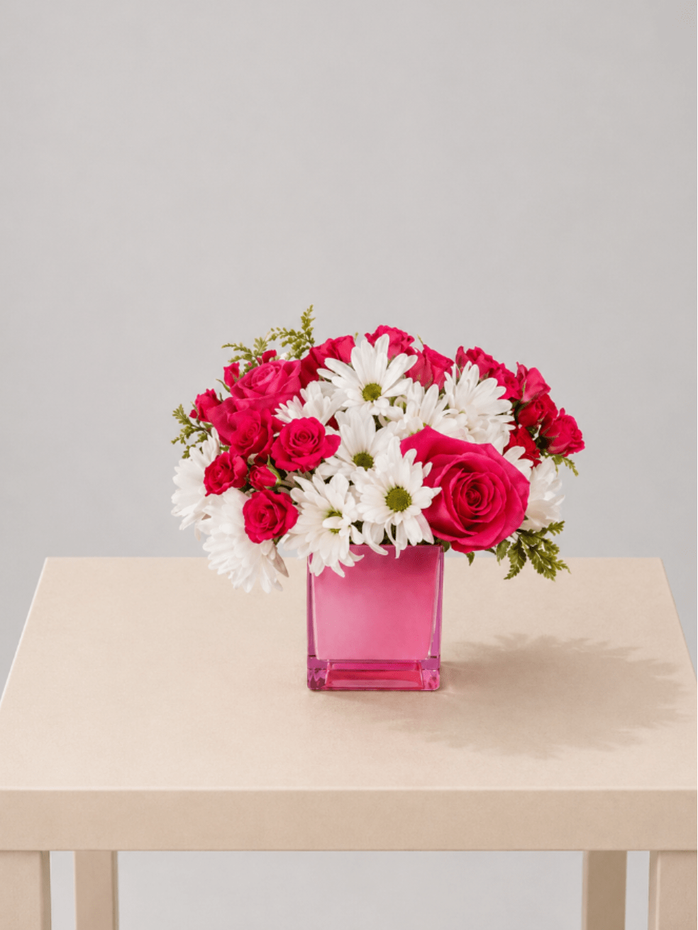Pink Pop Garden - A bright and cheerful flower arrangement featuring hot pink roses paired with crisp white daisies, beautifully designed in a modern pink glass cube. Fresh, fun, and full of energy, this design brings a playful yet polished touch to any space.  Perfect for:  birthdays, thank you gestures, celebrations, Mother’s Day, or sending a cheerful “just because” surprise.  Available for local flower delivery throughout Naples, Bonita Springs, Estero, Fort Myers and Fort Myers Beach.  Designer’s Choice: Each arrangement is uniquely designed using the freshest seasonal flowers available. Flower varieties, colors and containers may vary while maintaining the overall style, value and beauty of the design.