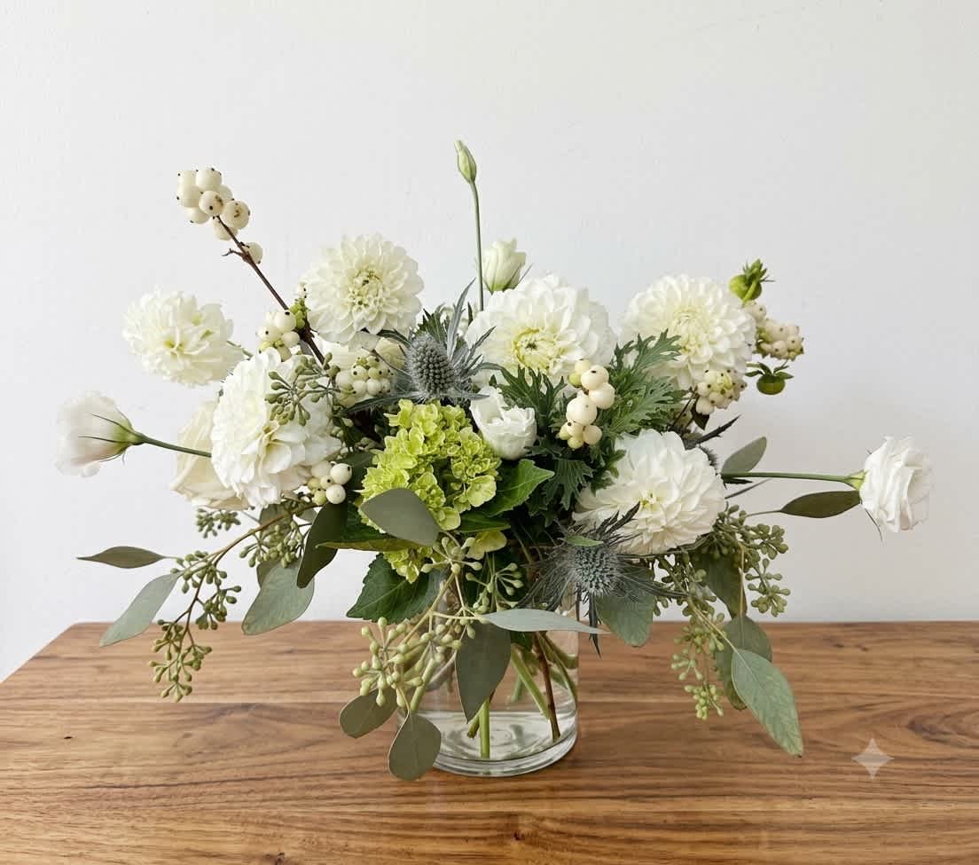 White and green floral arrangement in a clear glass vase