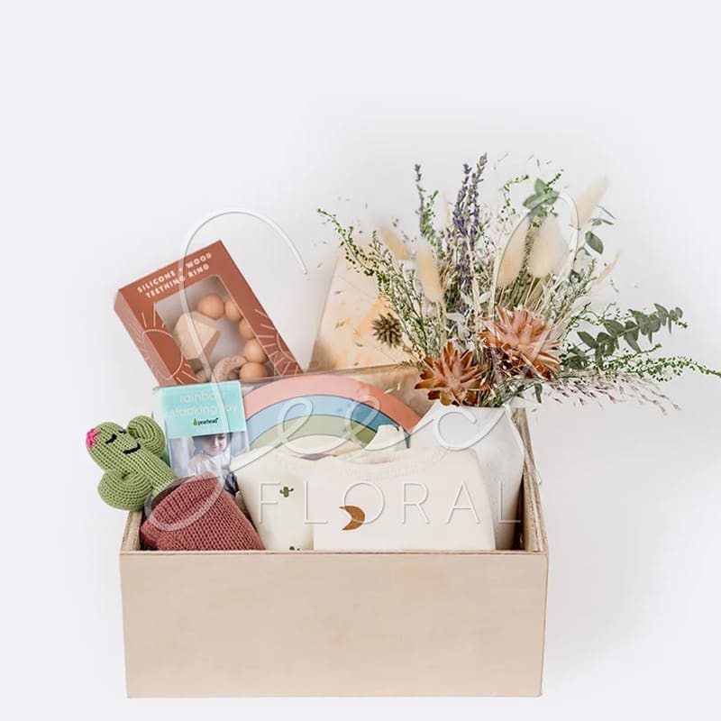 Gift box with dried flowers, baby items, and a cactus plush toy