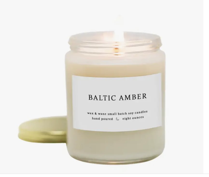 A scented candle in a glass jar with a gold lid
