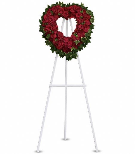 Heart-shaped red rose wreath on a white standing easel