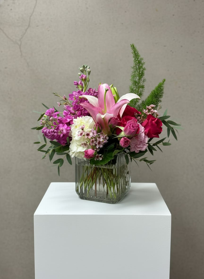 Pink and white floral arrangement in a glass vase