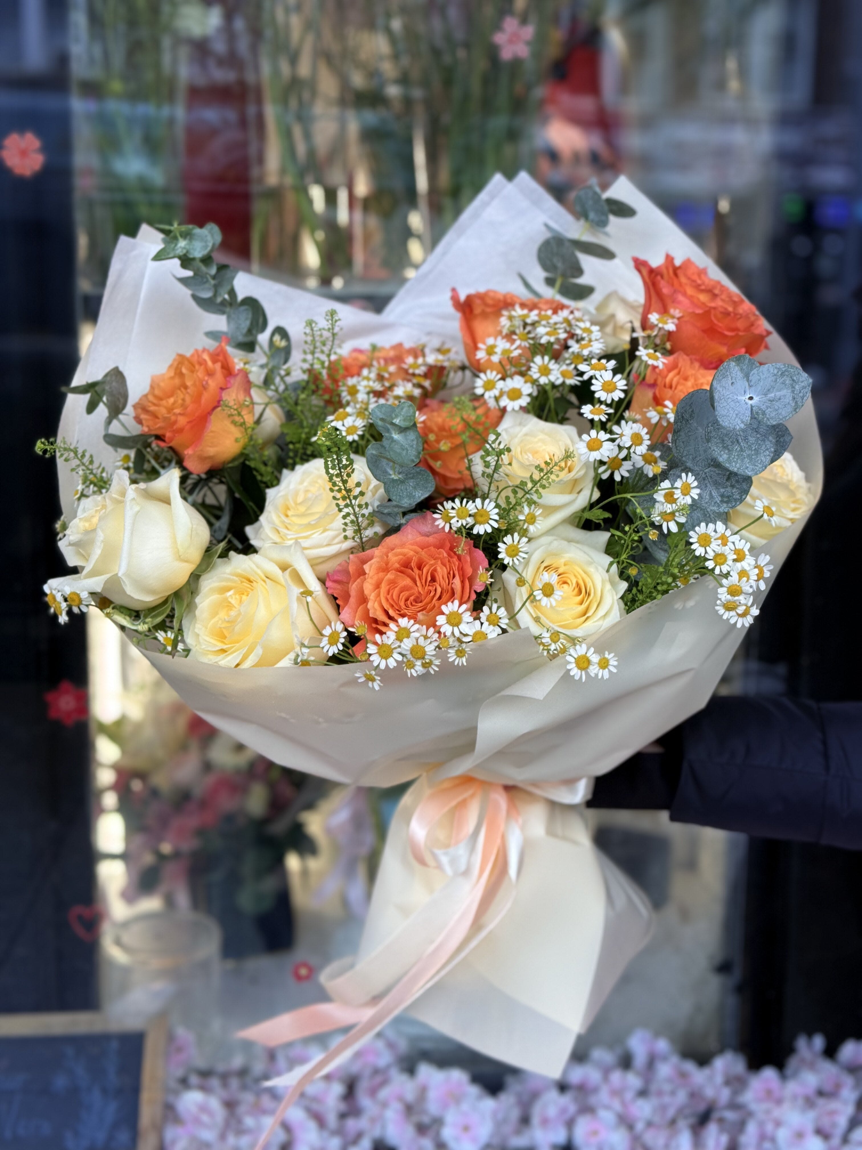Bouquet of orange and white roses with small white daisies