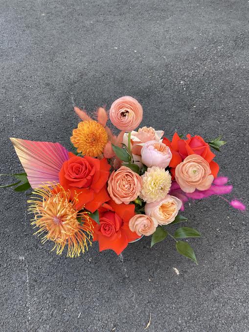 Out Of This World  - This unique arrangement will sweep anyone of their feet. Takes you to another planet. It is filled with roses, pin cushions, dried palm spears, bunny tails, garden roses, ranunculus, and dahlias. 