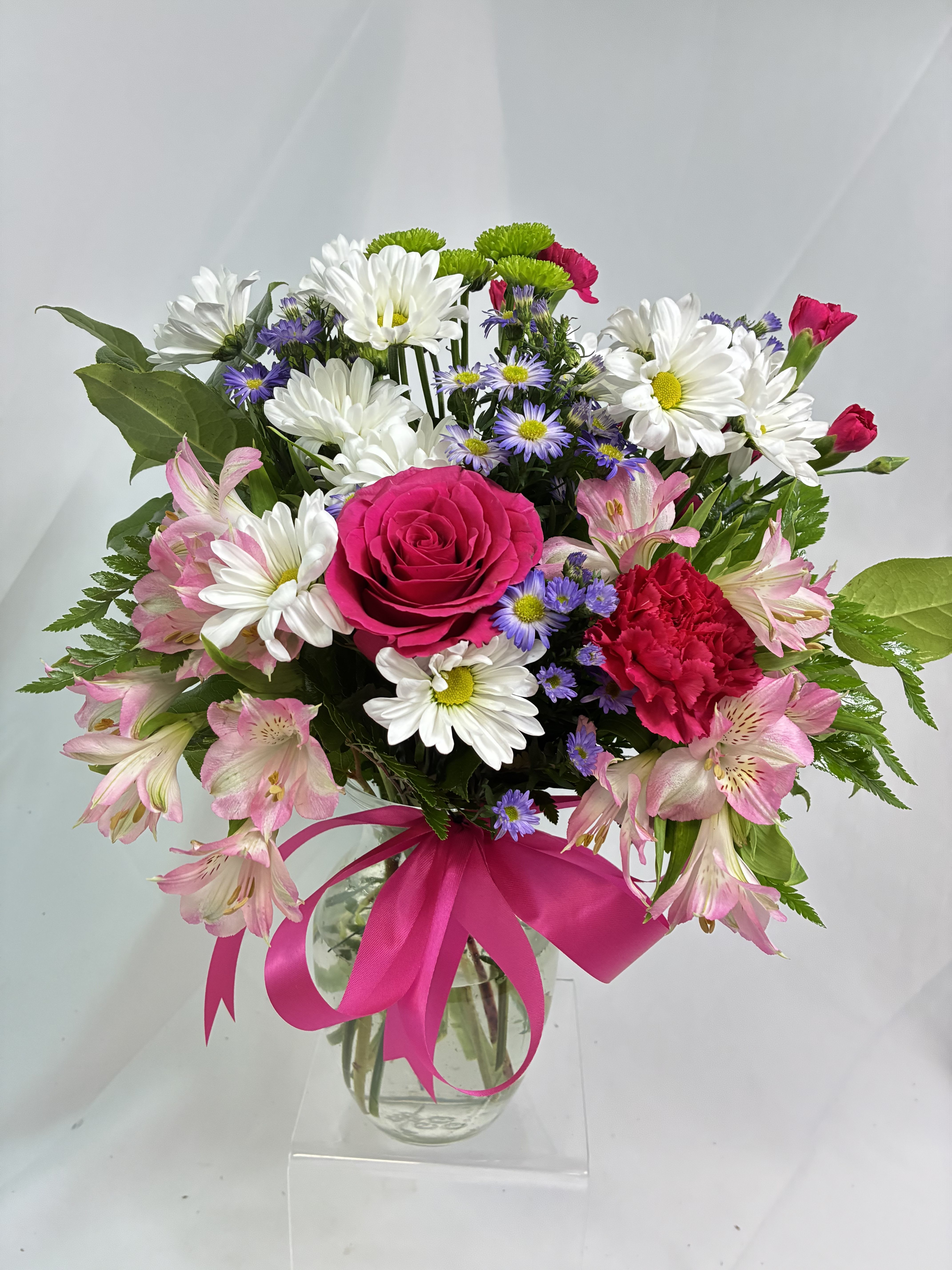 Pretty Petals - Looking for the prettiest bouquet in town? We've got the perfect all-around choice - a mix of blooms in breezy shades of pink white lavender and more all tied up with a big pink bow! A great way to make someone smile. A mix of fresh flowers such as spray roses daisy and button spray chrysanthemums Monte Cassino asters and limonium in shades of white pink green purple and lavender. Delivered in a vase adorned with a matching ribbon.