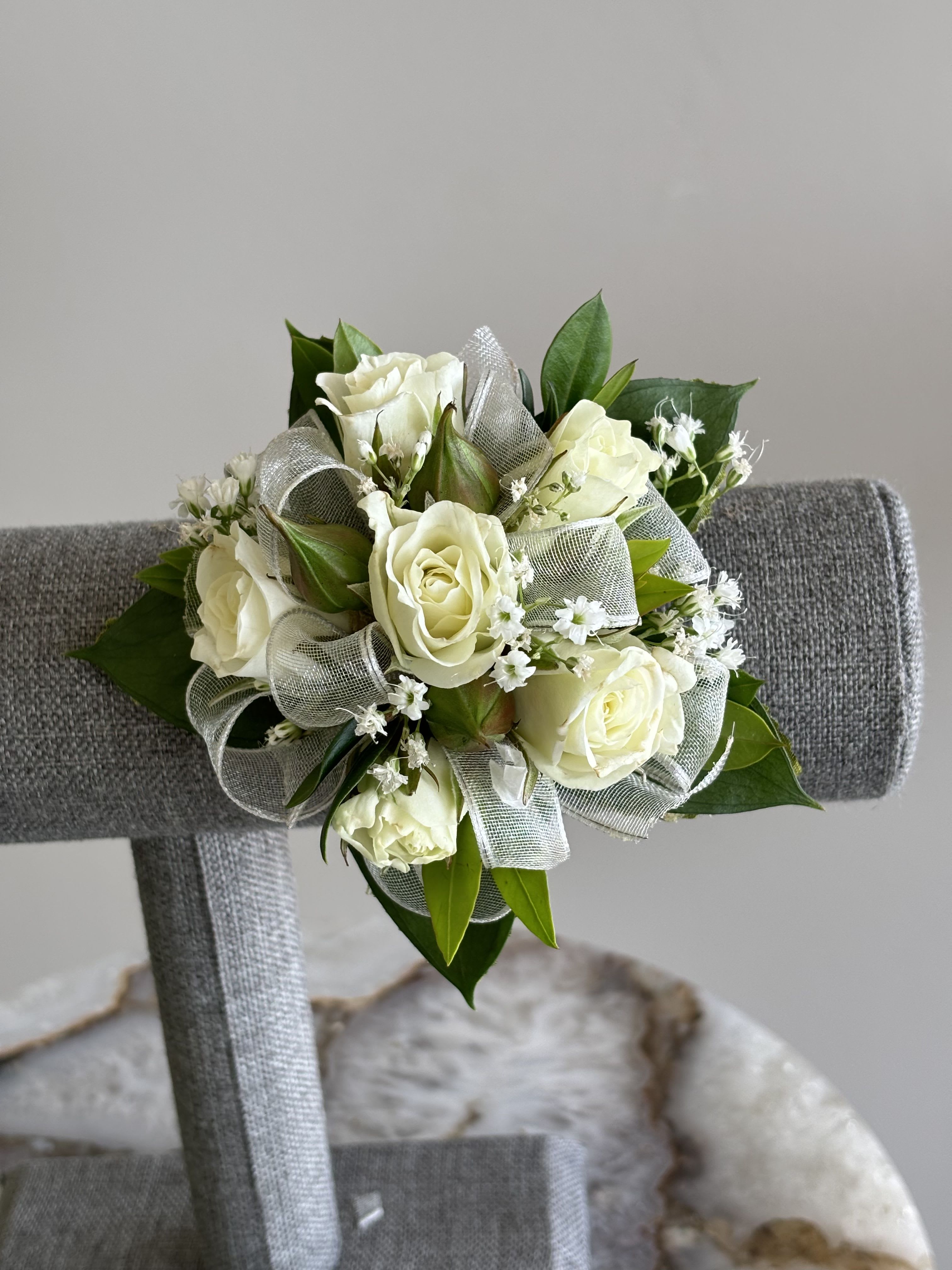 Customizable Prom Corsage (Please Read the Description for Details on Customization) - Photographed are multiple examples of corsages that we have made, you can leave notes about the ribbon color, flower color and if you would like to upgrade to bling or a bling band.   If you don't leave any details you will have an all white standard corsage built like the one in the first photo.    Standard Corsage Options with a standard stretchy band ($65): Ribbon Color: White, Silver, Pink, Red, Black or Ivory Spray Rose Color: White, Red, Light Pink, Hot Pink, Orange, Yellow Optional Add: Dark and Light Blue Delphinium Bling to match is an additional $5 (Deluxe Option) You can upgrade to a rhinestone, pearl or scrunchy wristband for an additional $10 (Premium Option)