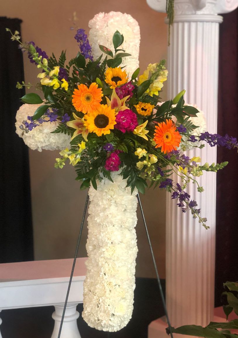 Standing floral cross with white flowers and bright mixed blooms