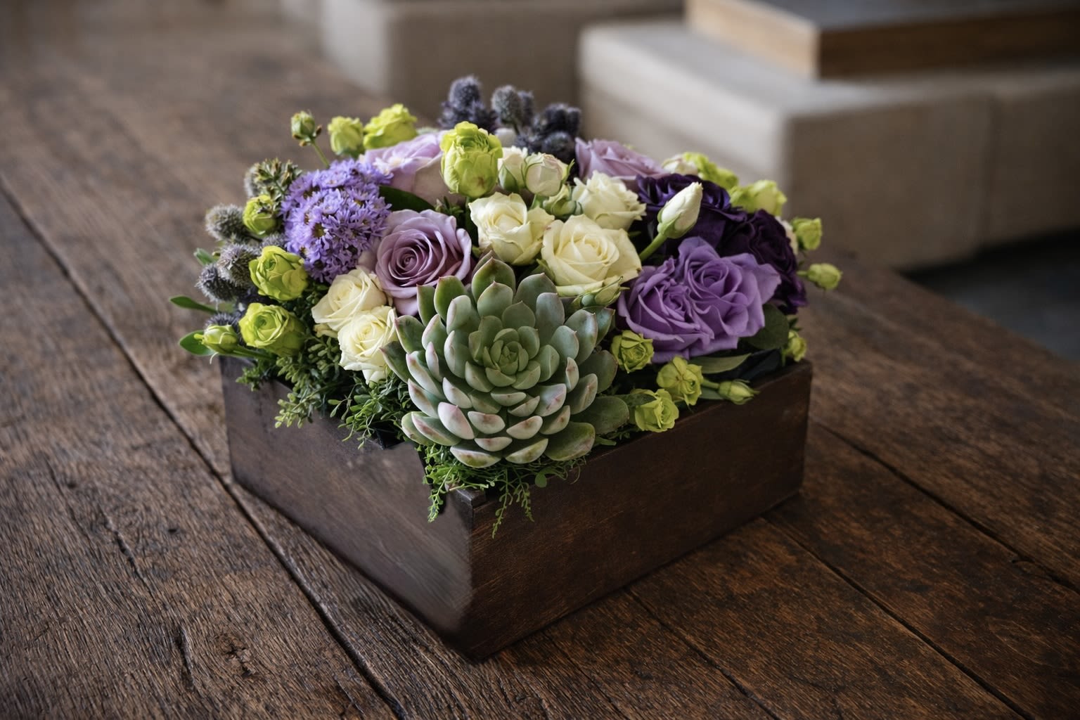 Purple and cream roses with a succulent in a wooden box