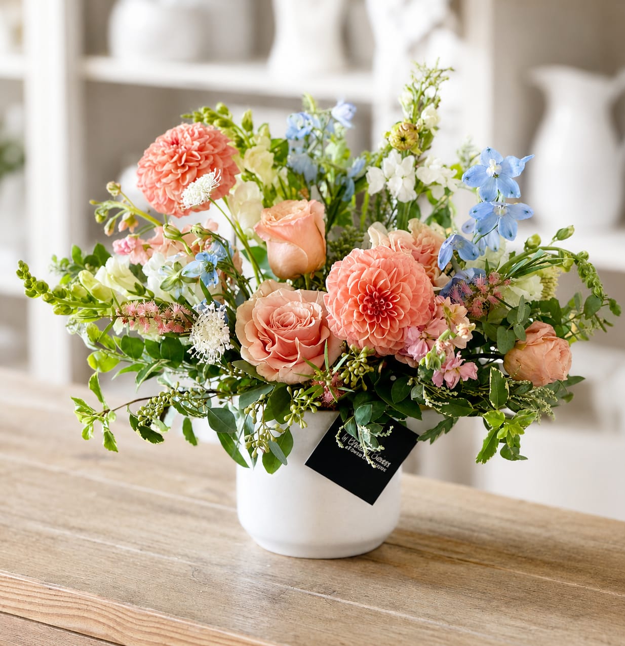 Mixed pastel flower arrangement in a white vase