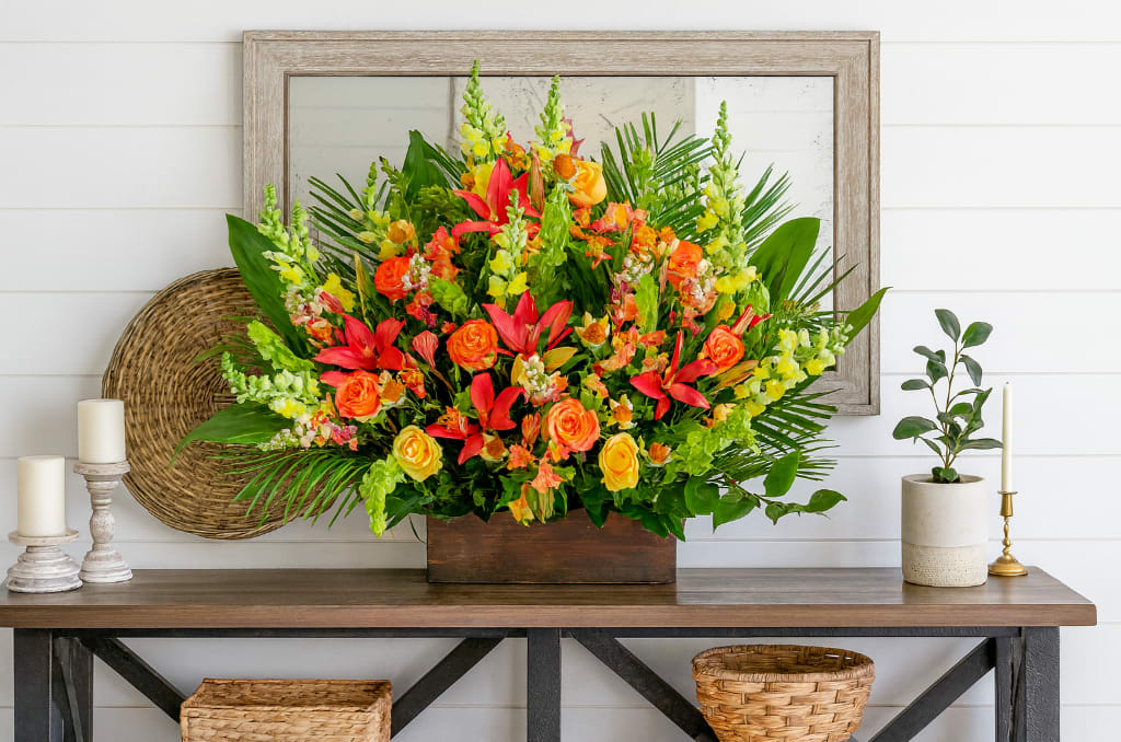 Bright tropical flower arrangement in a wooden box on a table