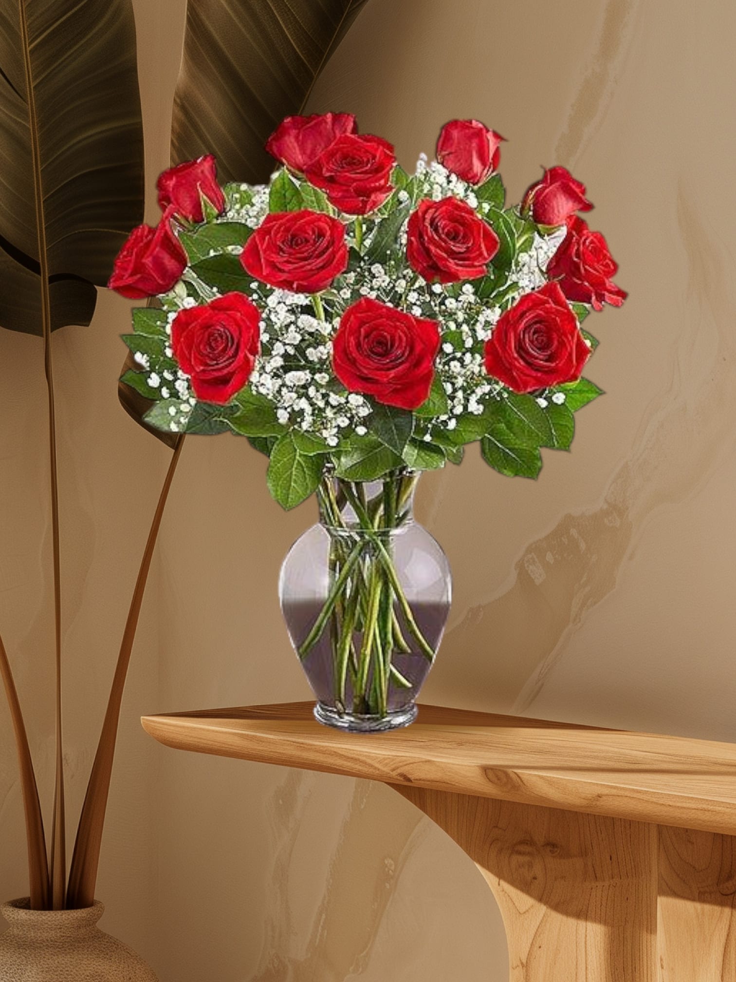 Classic ginger Red - A timeless arrangement of velvety red roses paired with delicate gypsophila, also known as baby's breath, creating a romantic and ethereal display. Presented in a clear glass vase.       
