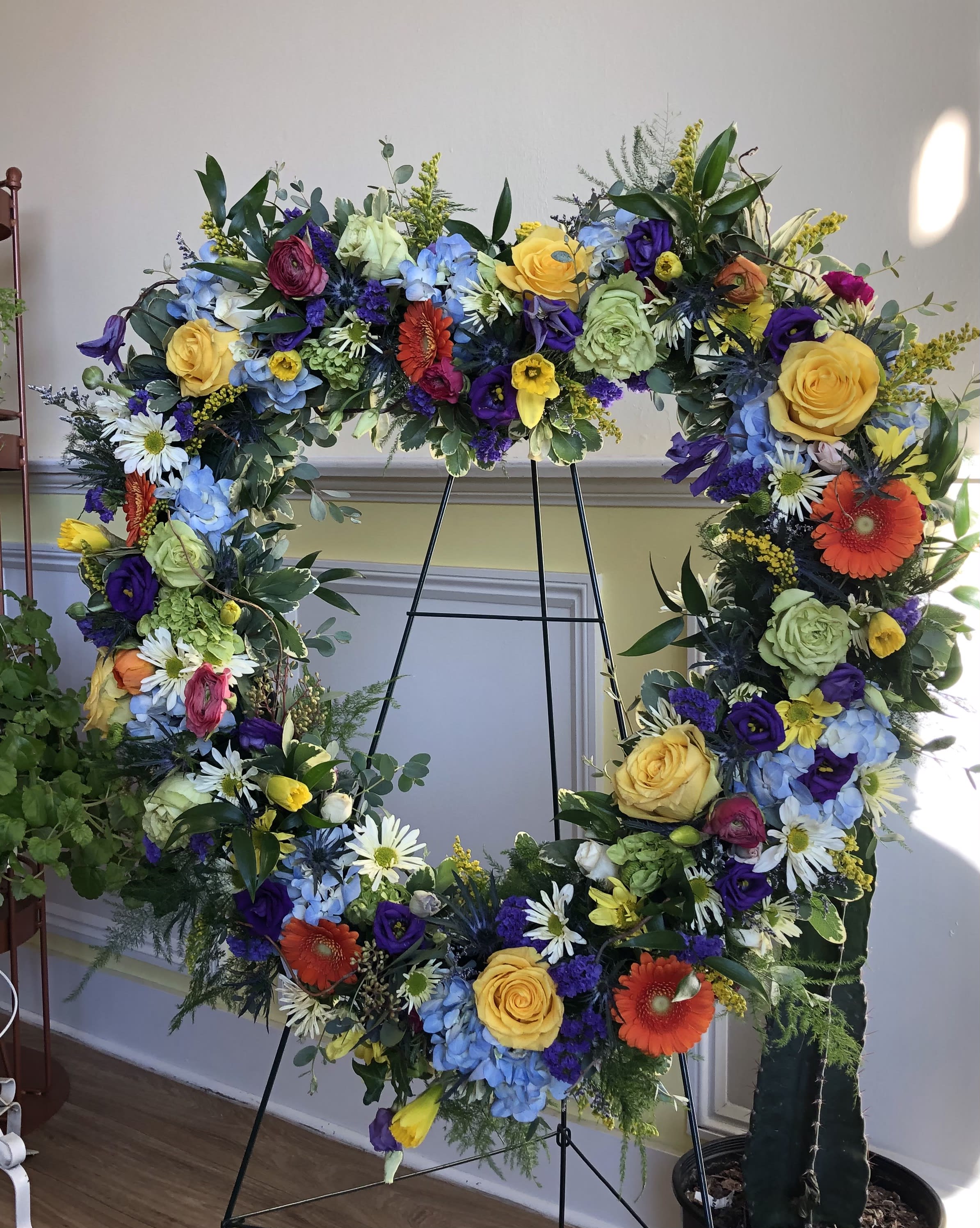 Large floral wreath on an easel with multicolored flowers