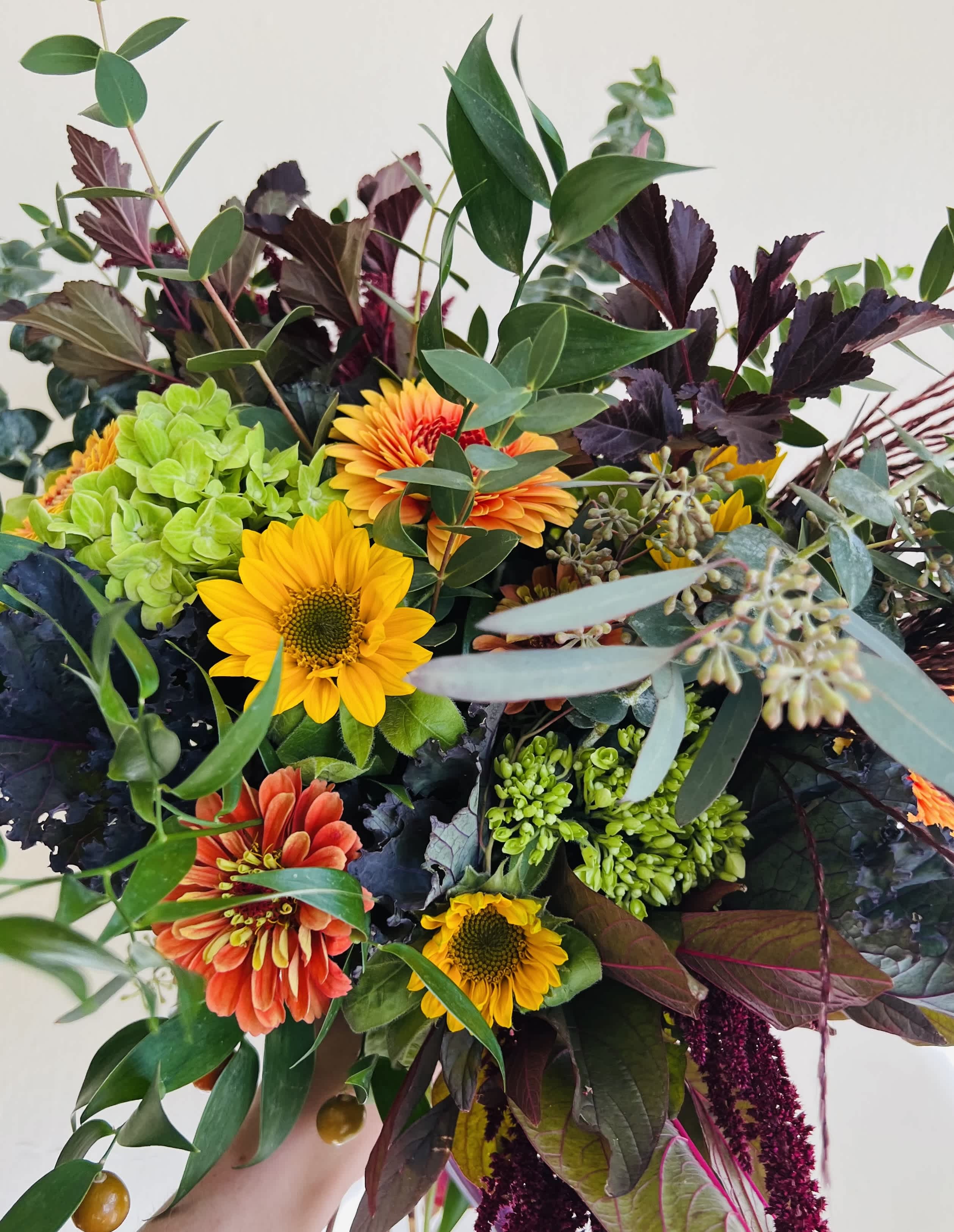 Mixed bouquet with sunflowers, orange blooms, and green hydrangea