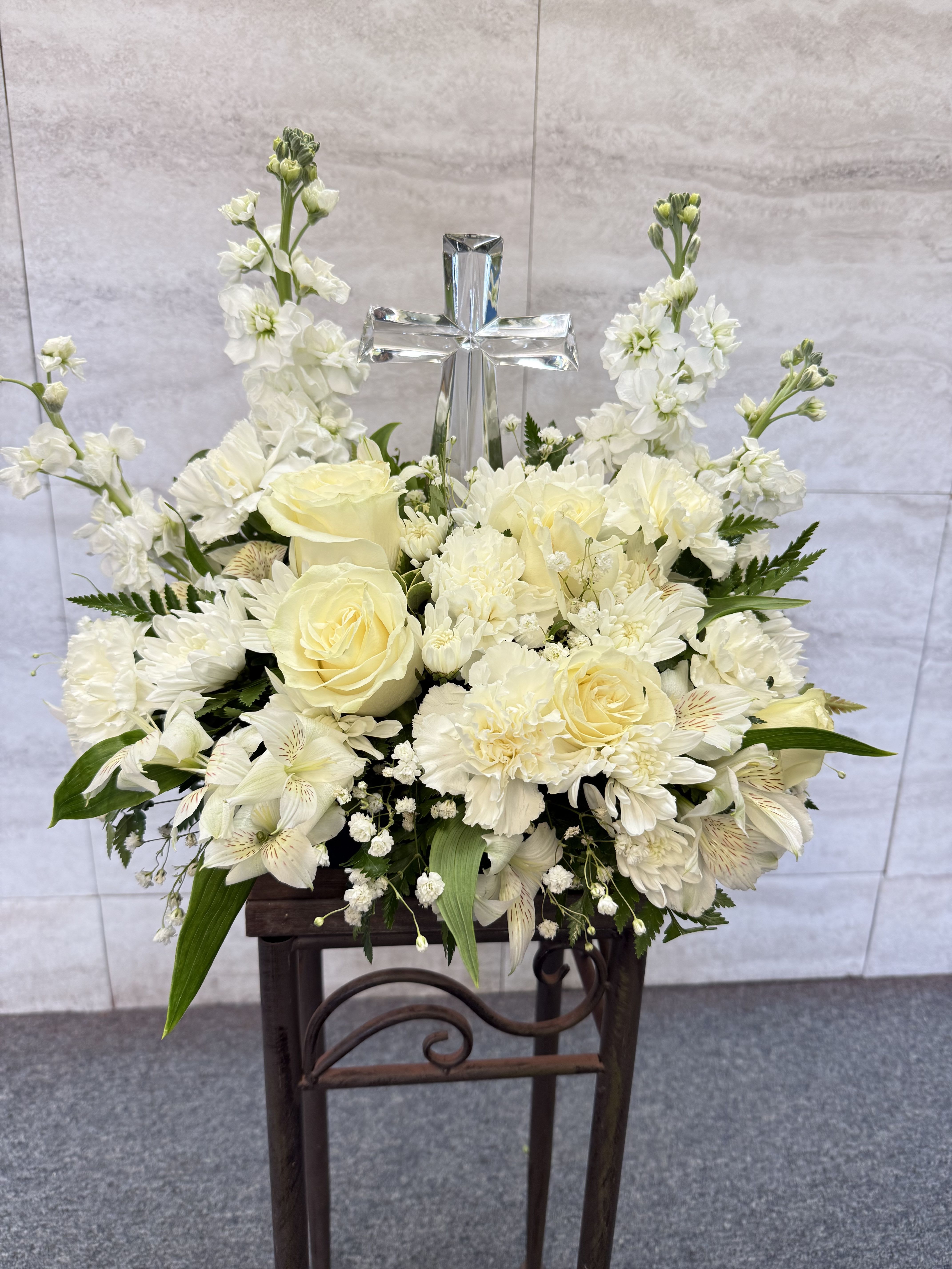 White floral arrangement with a silver cross centerpiece