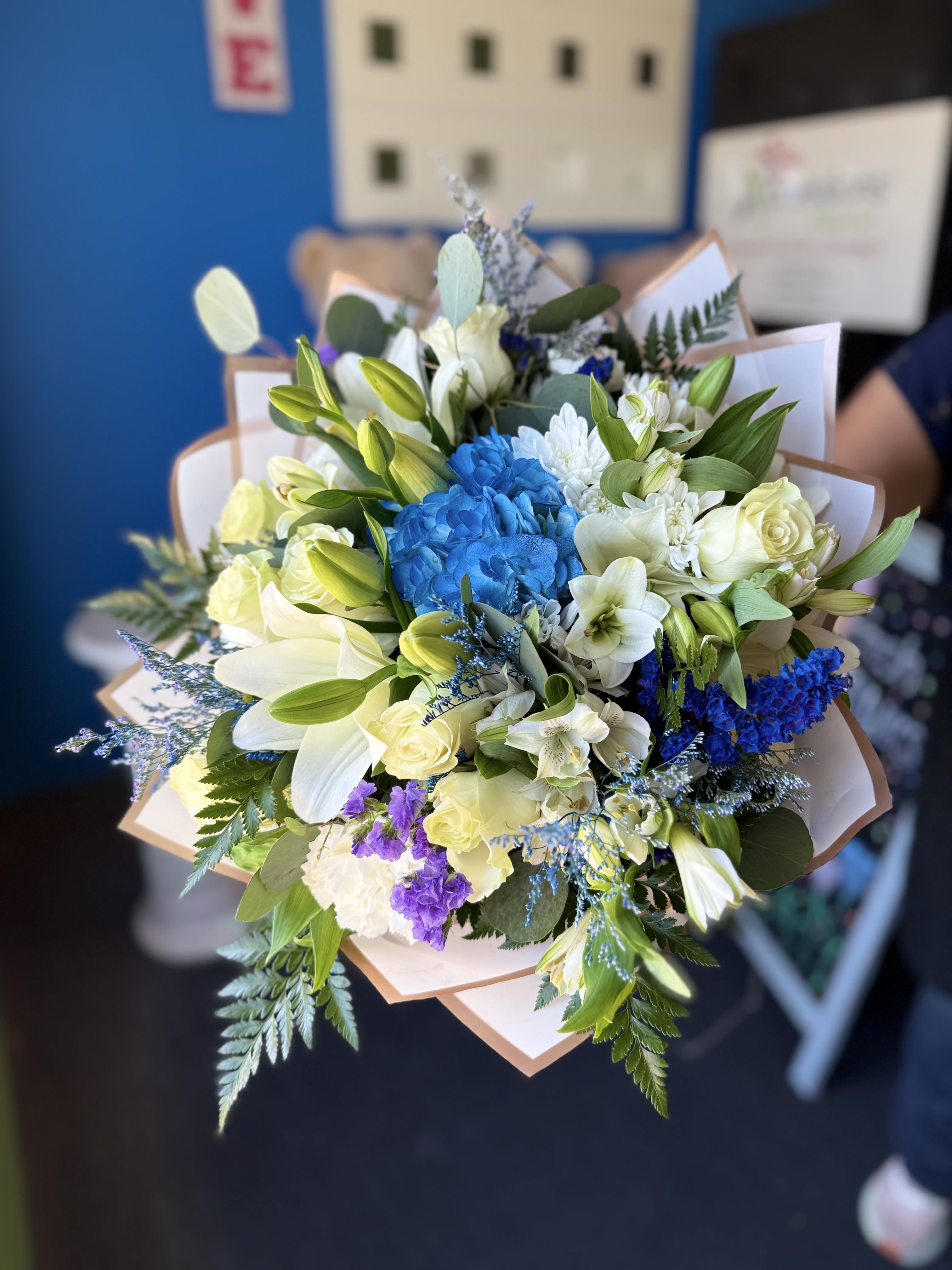 Blue - This blue-wrapped bouquet features a 'buchon' style and will include the same or similar flowers. Please note: this is a hand-wrapped bouquet and does not include a vase.