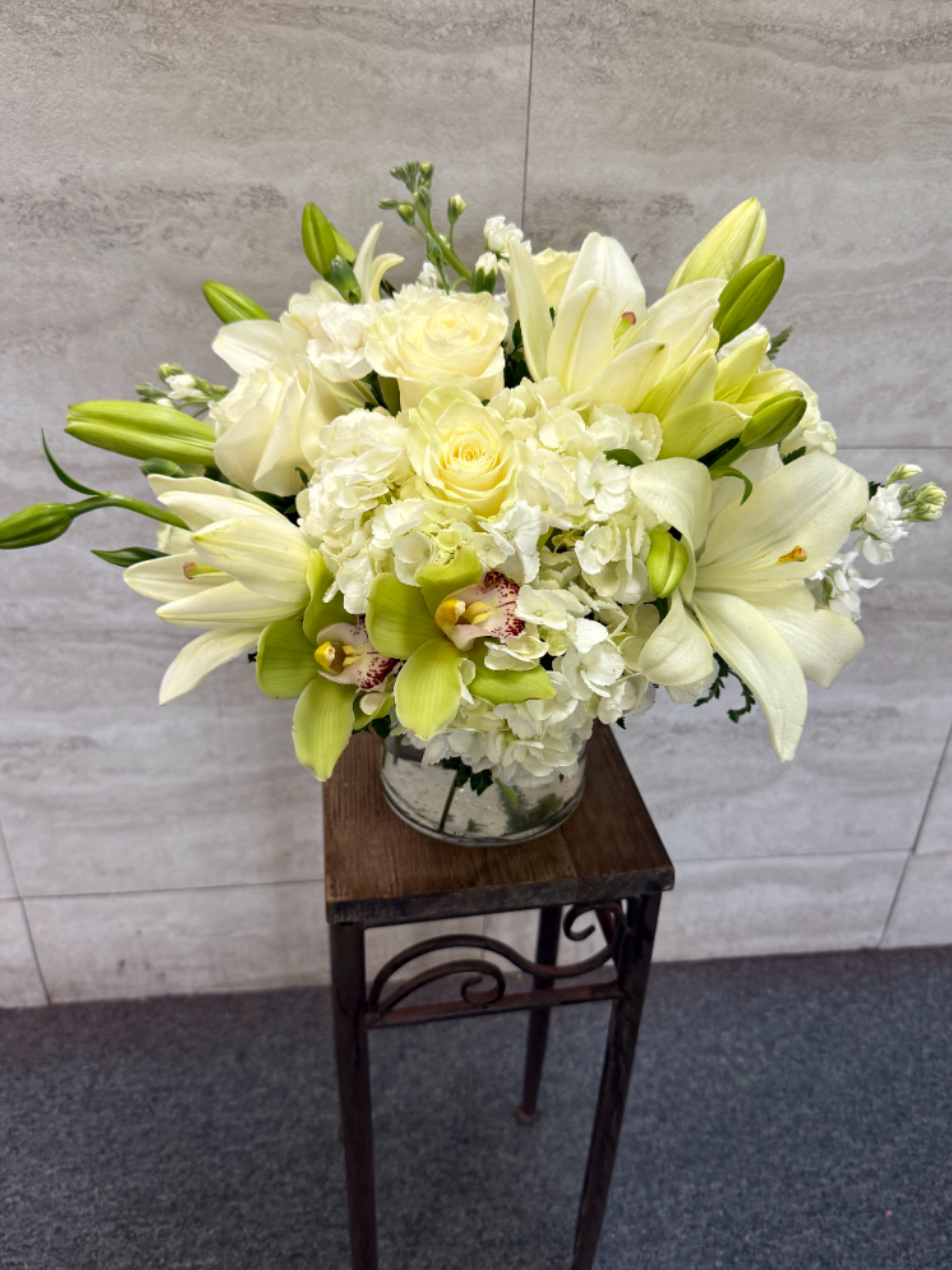 Beauty in White - All-white arrangement of lilies, roses and orchids for a timeless, elegant touch-perfect for sympathy, weddings, or serene home decor.