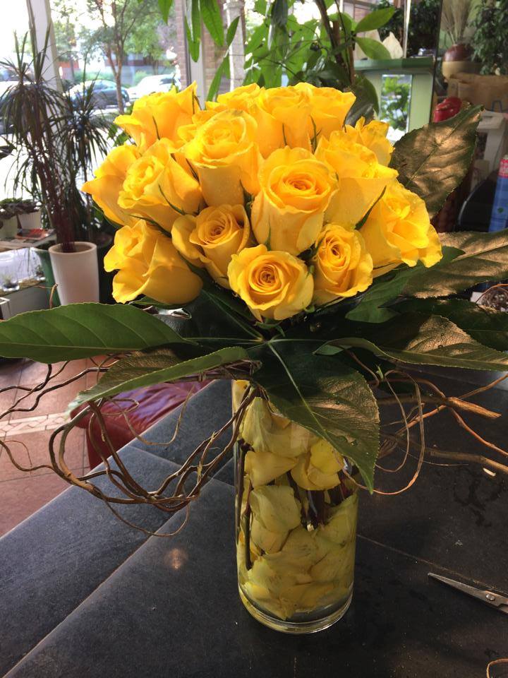 Yellow roses arranged in a clear glass vase