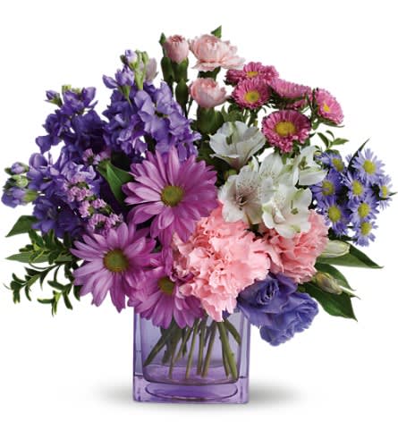 Purple and pink mixed bouquet in a square glass vase