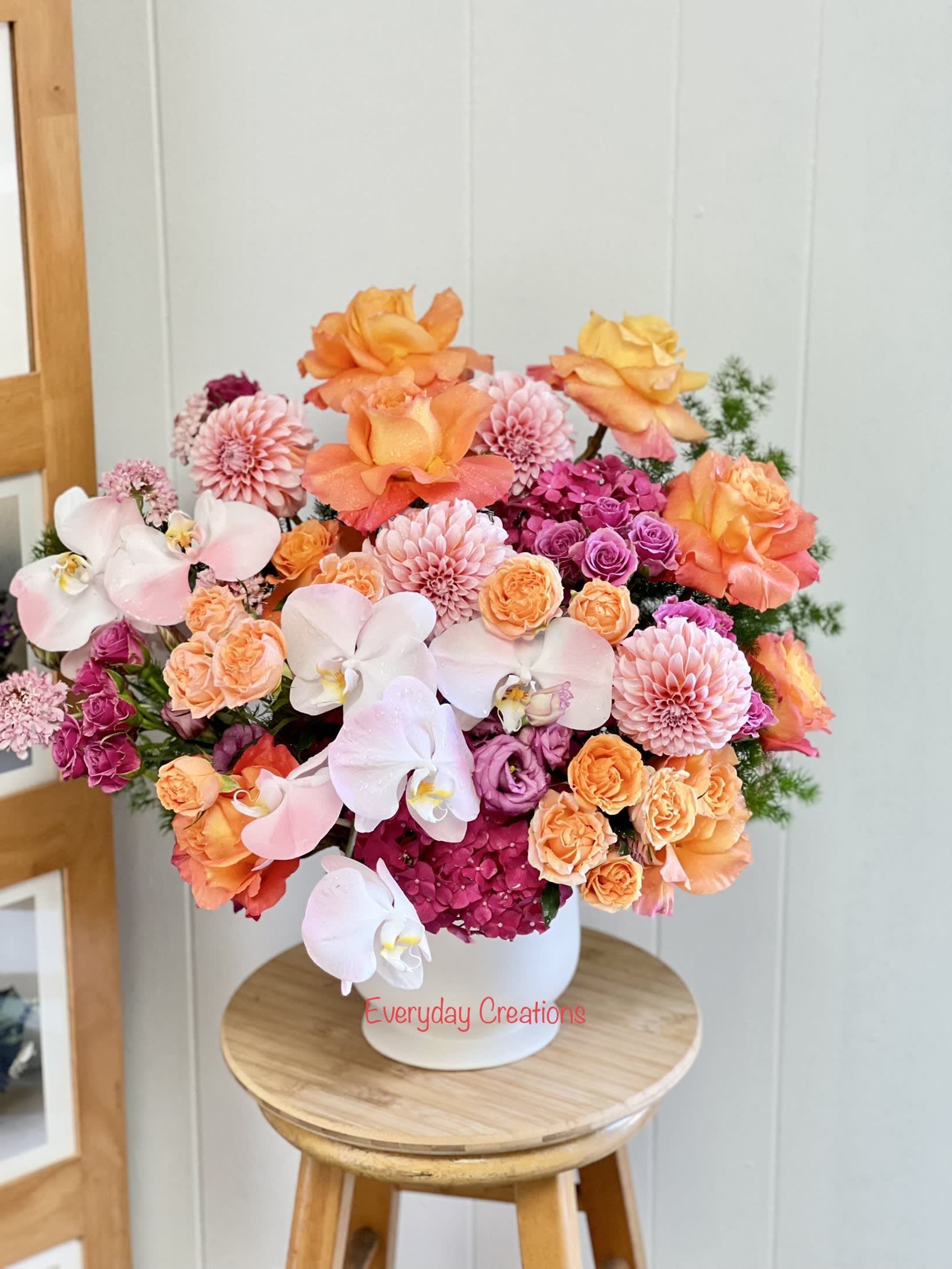 Bouquet of orange, pink, and white flowers in a white vase