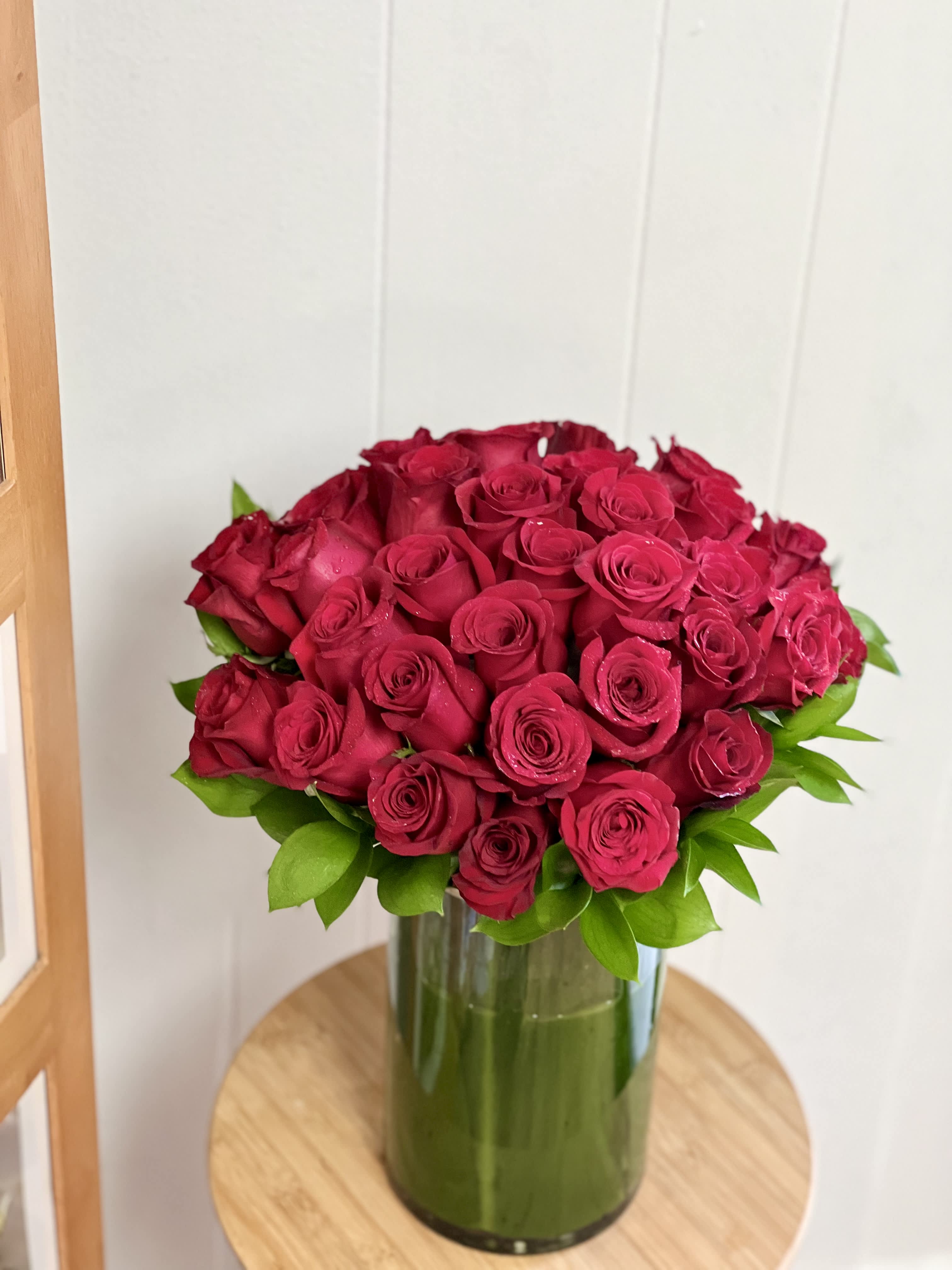 Red rose bouquet in a tall glass vase