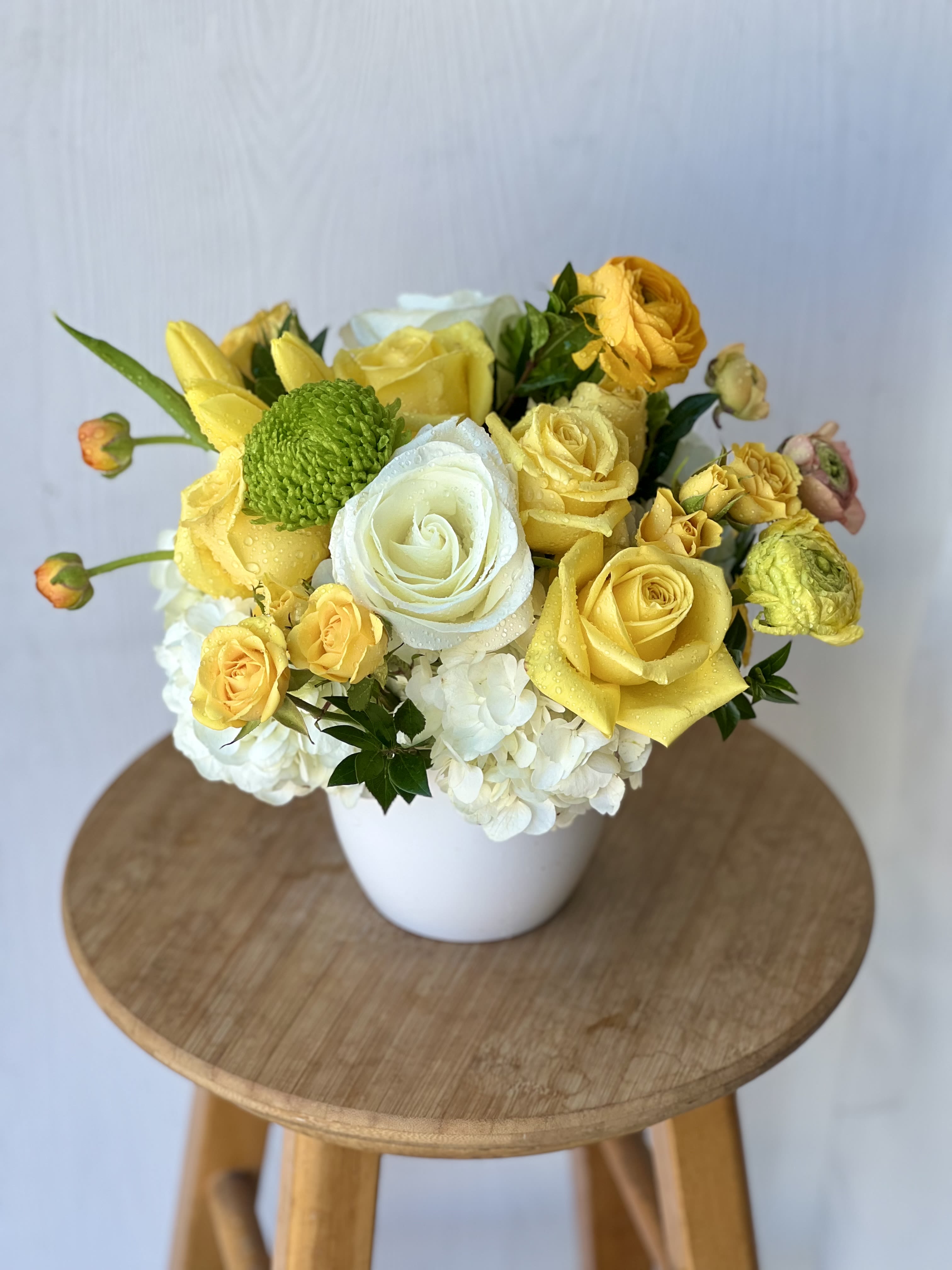 Yellow and white rose bouquet in a white vase