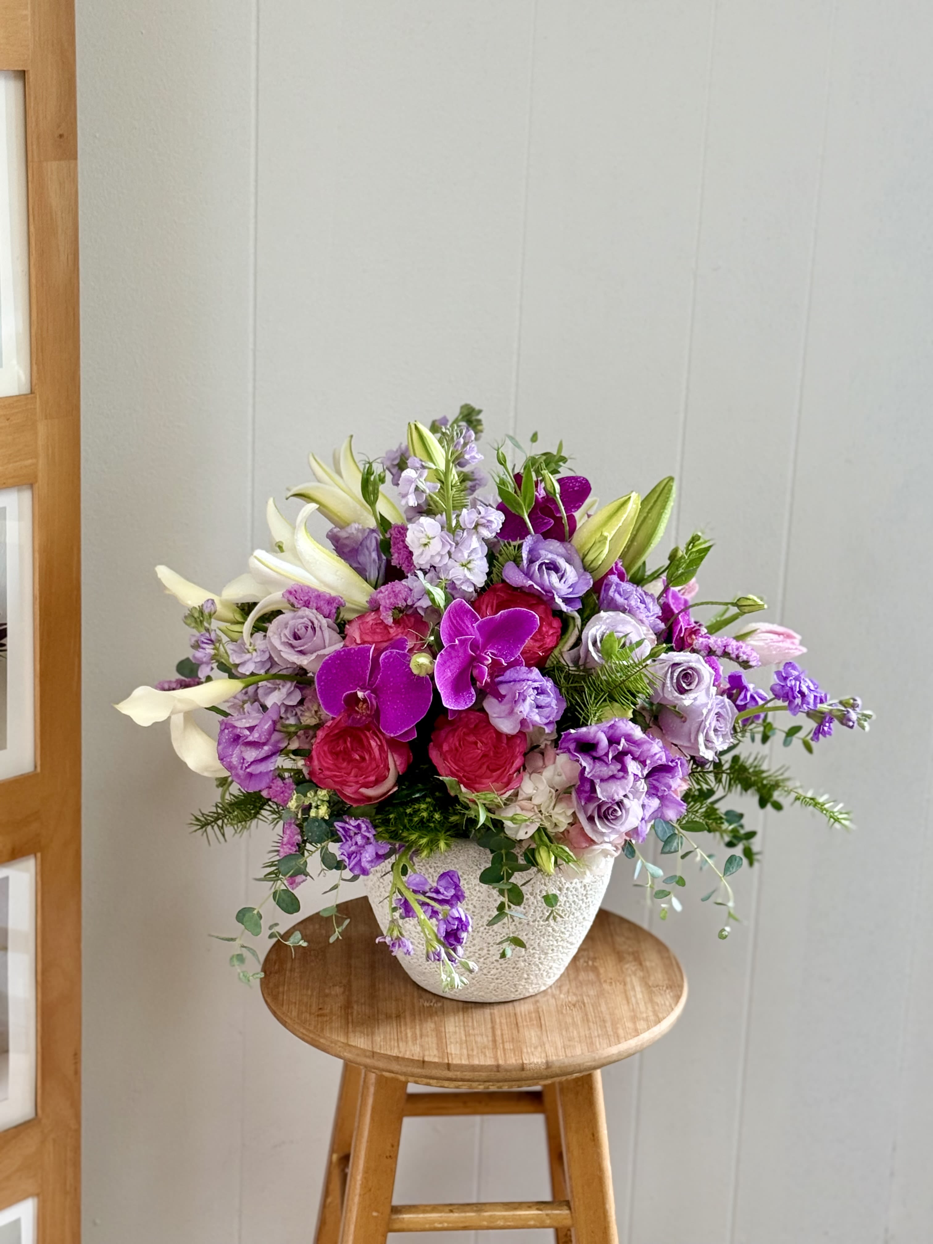 EC104 Sweetheart Garden - Make a breathtaking statement with  a lavish floral masterpiece designed to impress. This large premium arrangement features an elegant blend of vibrant purple orchids, fragrant lilies, lavender roses, lisianthus, hydrangea, and seasonal blooms artfully designed in a modern textured ceramic container. Overflowing with rich color, luxurious textures, and cascading greenery, this sophisticated arrangement brings beauty and elegance to any celebration or space. Perfect for birthdays, anniversaries, Mother’s Day, sympathy gestures, luxury gifting, or upscale home décor, this floral design creates a stunning focal point wherever it’s displayed. Features: Large luxury floral arrangement Premium orchids, lilies, roses, lisianthus &amp; hydrangea Designer textured ceramic container Elegant garden-style design with cascading greenery Perfect for gifting and special occasions Handcrafted with fresh seasonal blooms