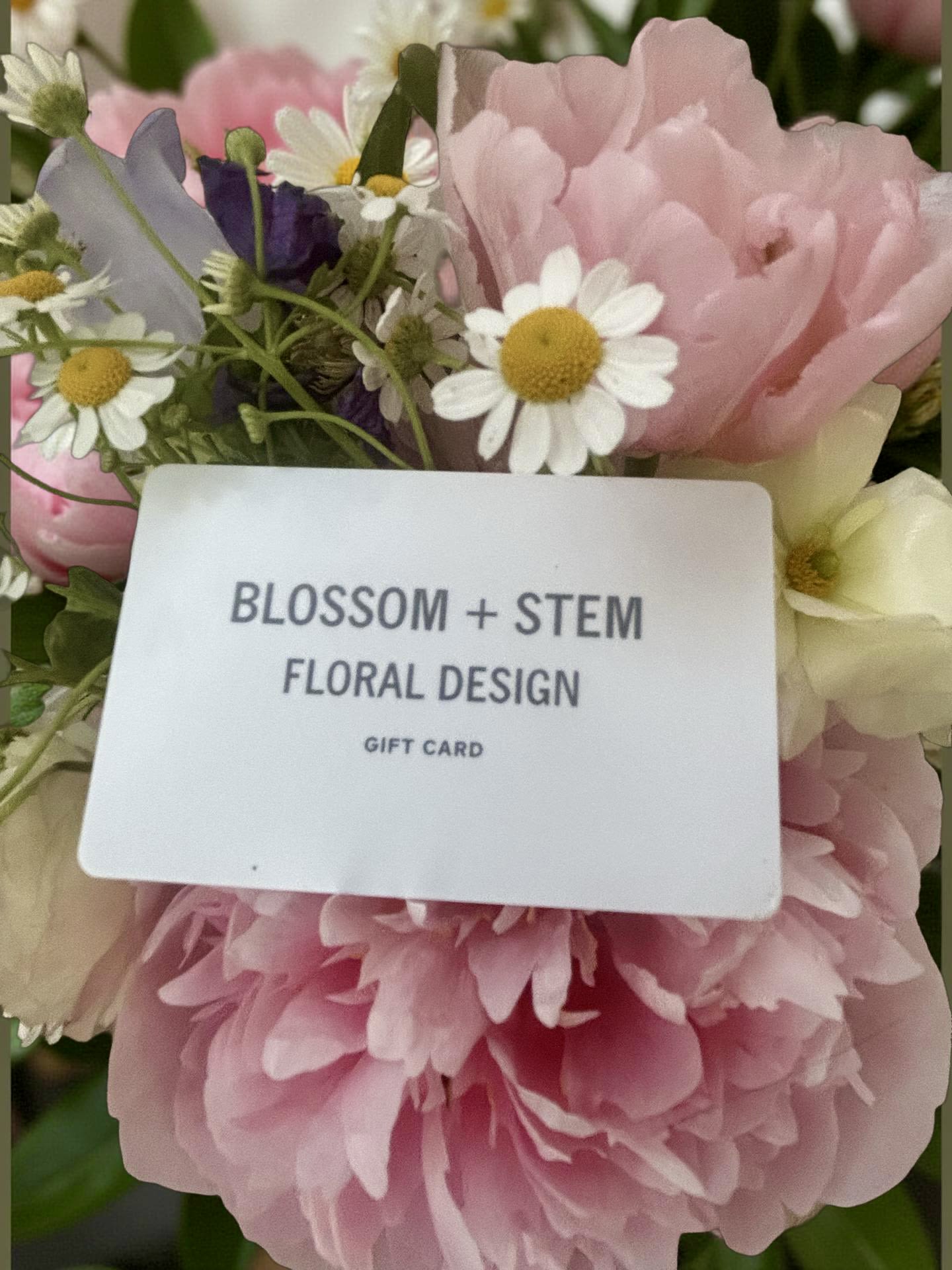 Pink and white flowers with a gift card in the center
