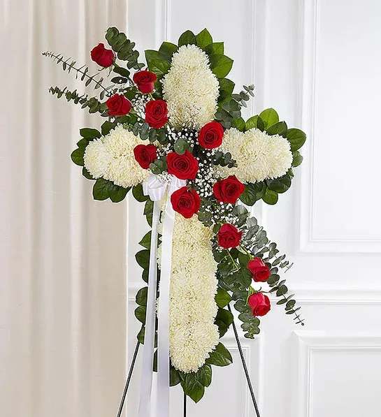 Standing floral cross with red roses and white chrysanthemums on an easel