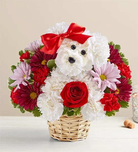 Flower arrangement shaped like a dog in a wicker basket with a red bow