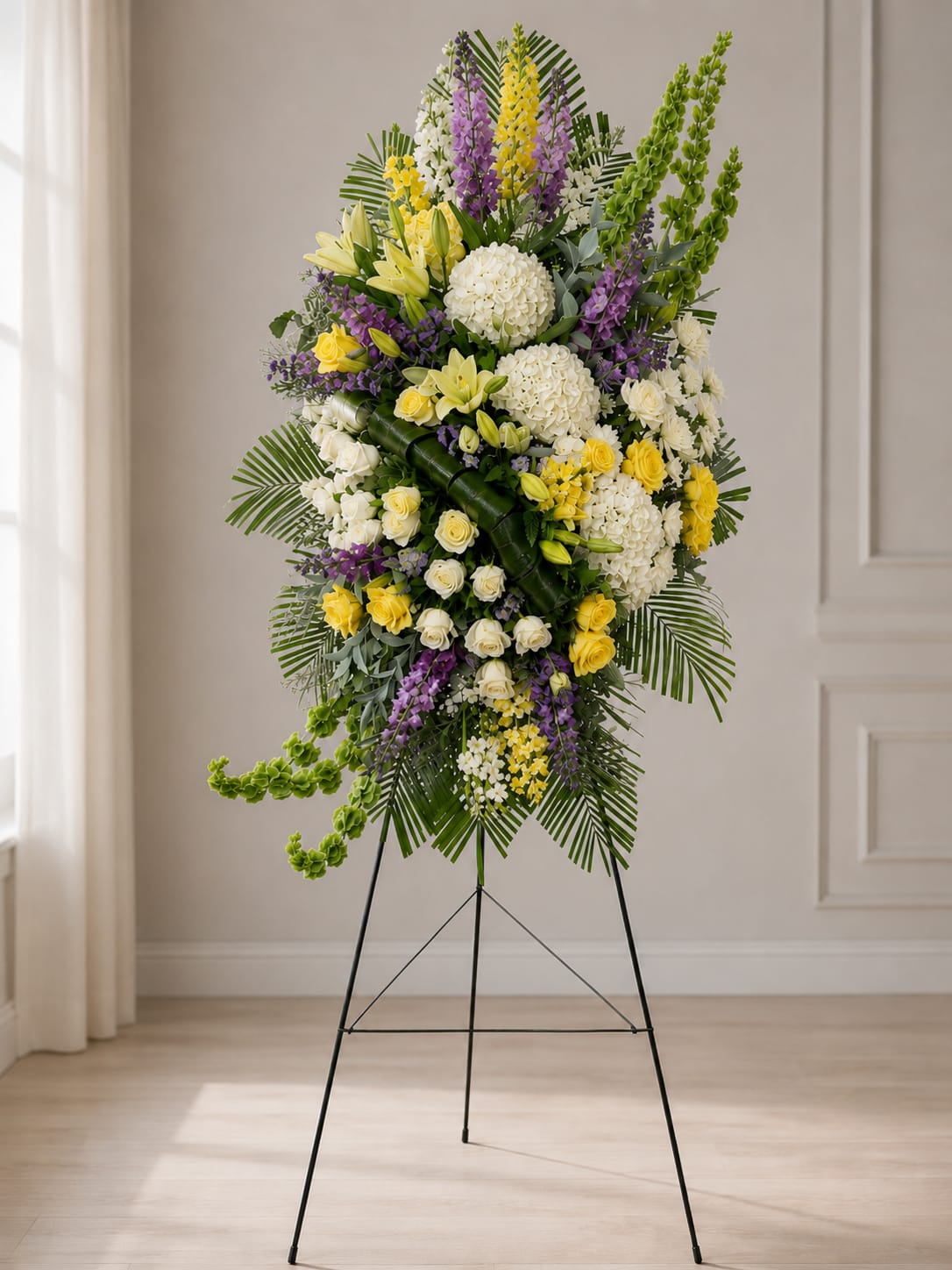 Golden Remembrance Standing Sympathy Spray - The Emerald Grace Standing Sympathy Spray is a stunning 92-inch tall(7.5 feet) funeral easel arrangement designed with elegant white roses, hydrangeas, lilies, lush greenery, and fresh green Bells of Ireland. This large standing spray creates a graceful and memorable tribute for funerals, memorial services, and celebration of life ceremonies. A beautiful choice for expressing sympathy with elegance and peace.
