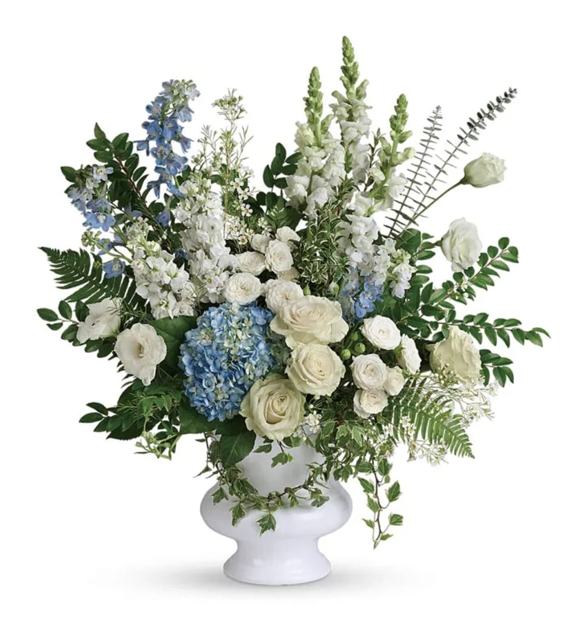 White and blue floral arrangement in a white urn vase