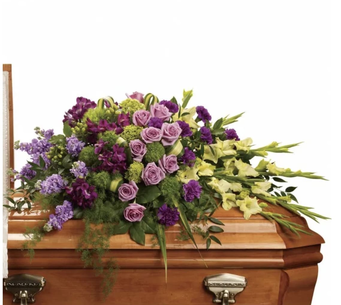 Purple and yellow floral spray on a wooden casket