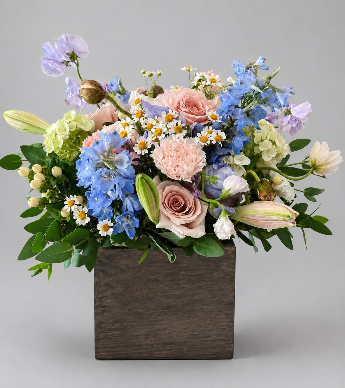 Mixed bouquet of pastel flowers in a wooden box