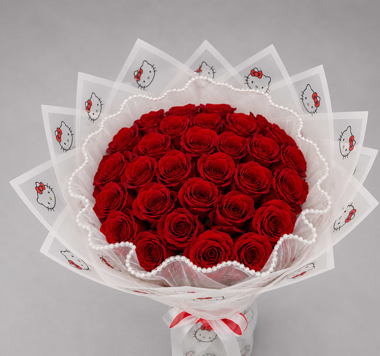 Bouquet of red roses wrapped in Hello Kitty printed paper with a white ribbon