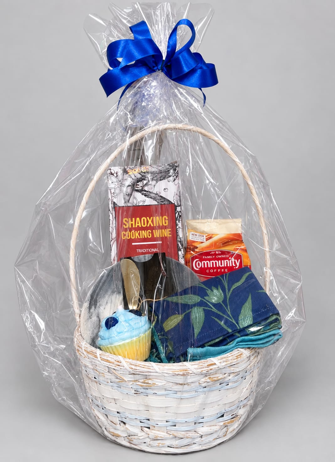 Gift basket with cooking wine, coffee, napkins, and a cupcake-shaped item