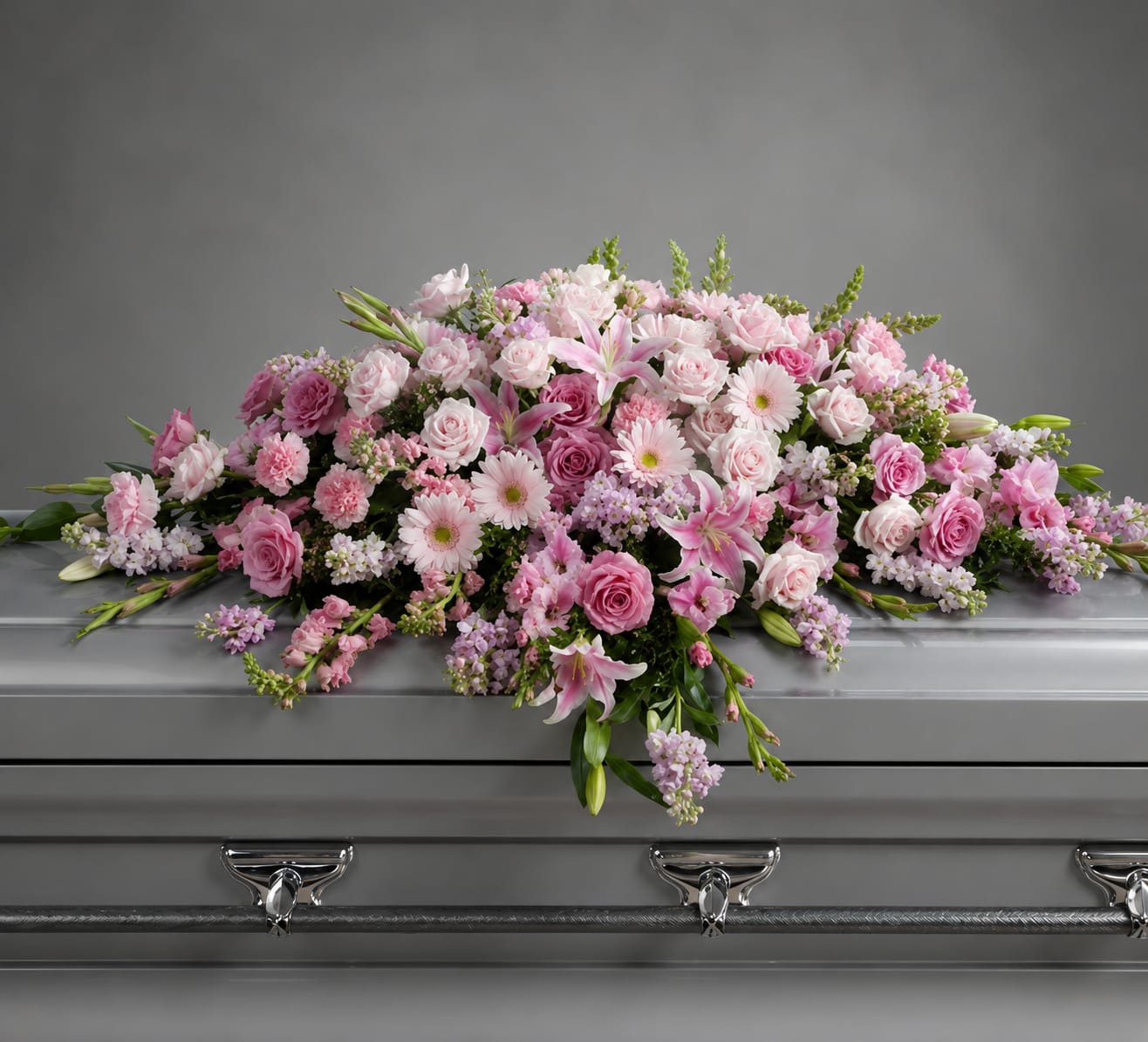 Pink floral spray arranged on a silver casket