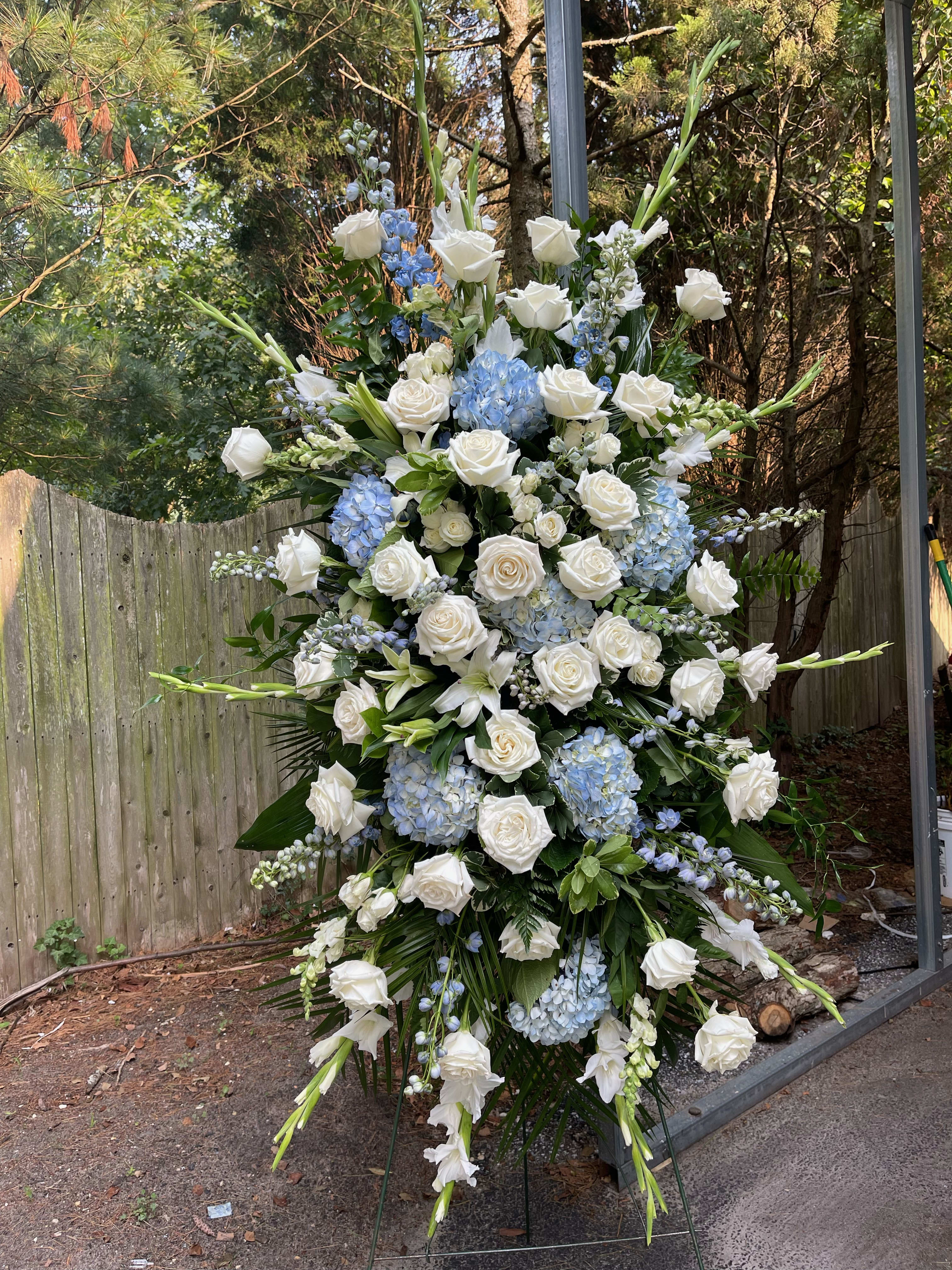 Large standing floral spray with white roses and blue hydrangeas