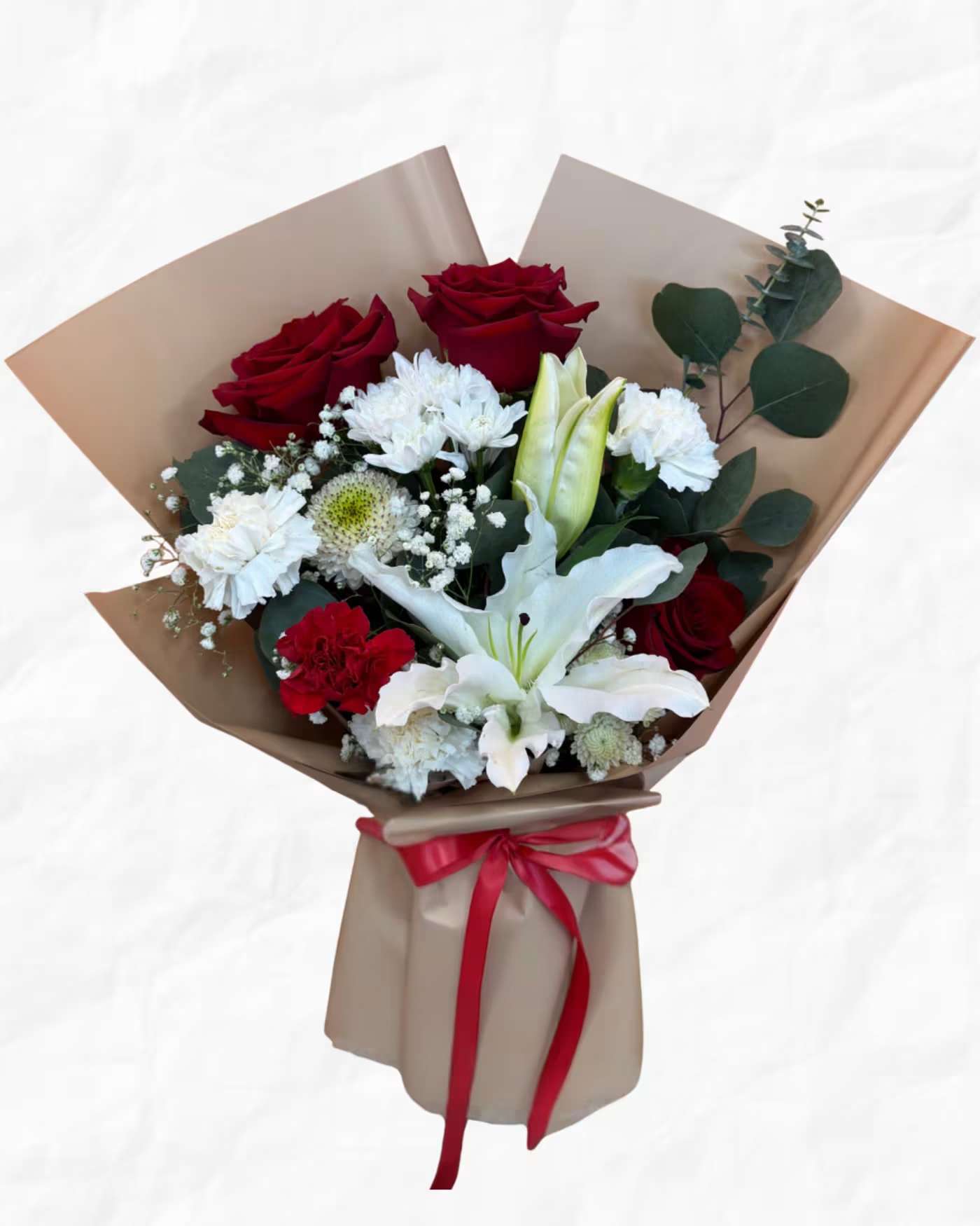 Bouquet of red roses, white lilies, and white filler flowers wrapped in brown paper