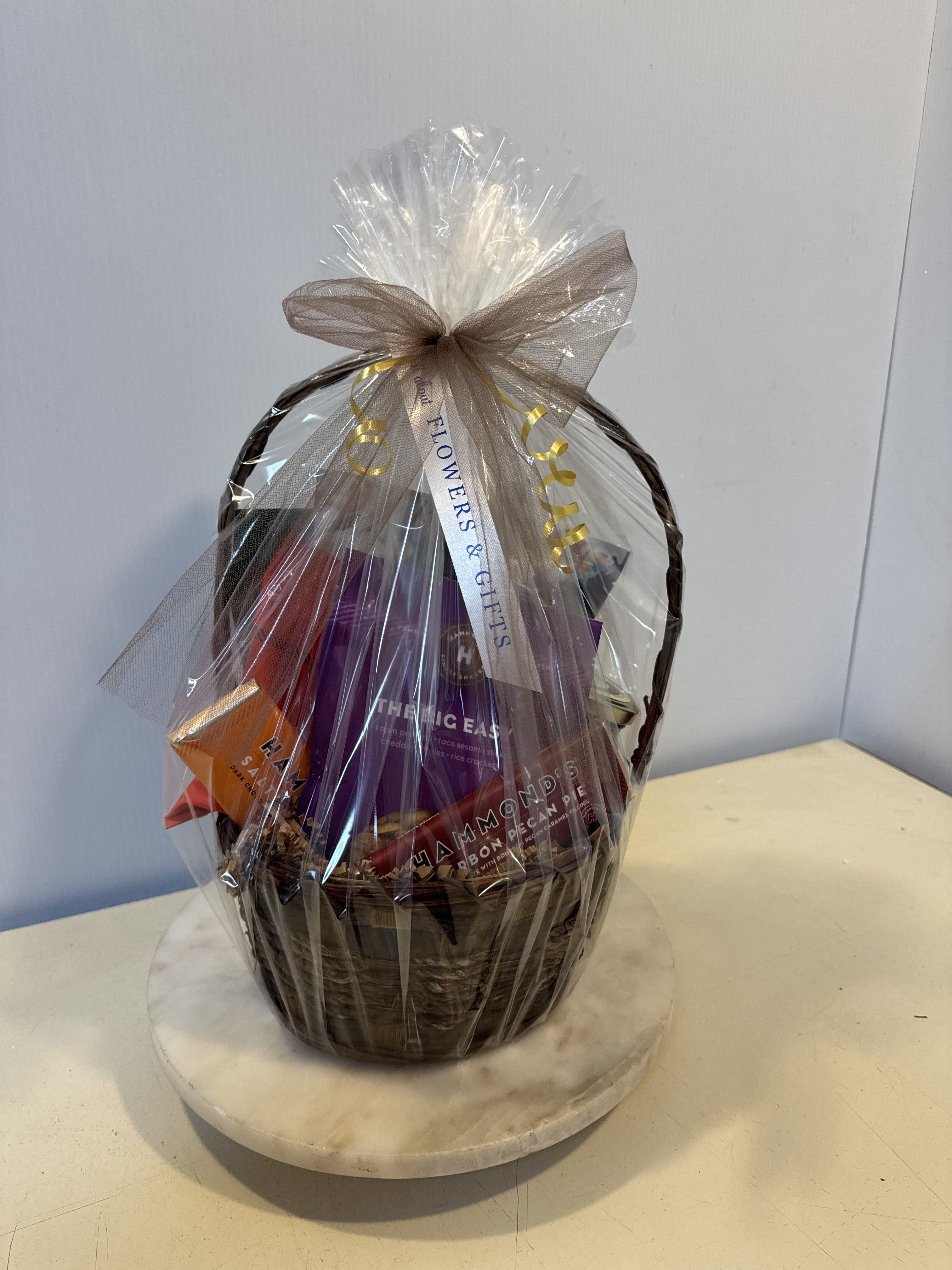 Gift basket wrapped in clear cellophane with a bow
