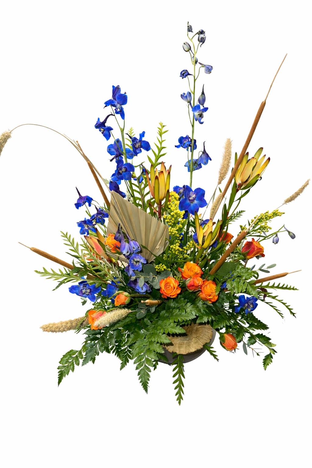 Blue and orange floral arrangement with tall stems in a low container