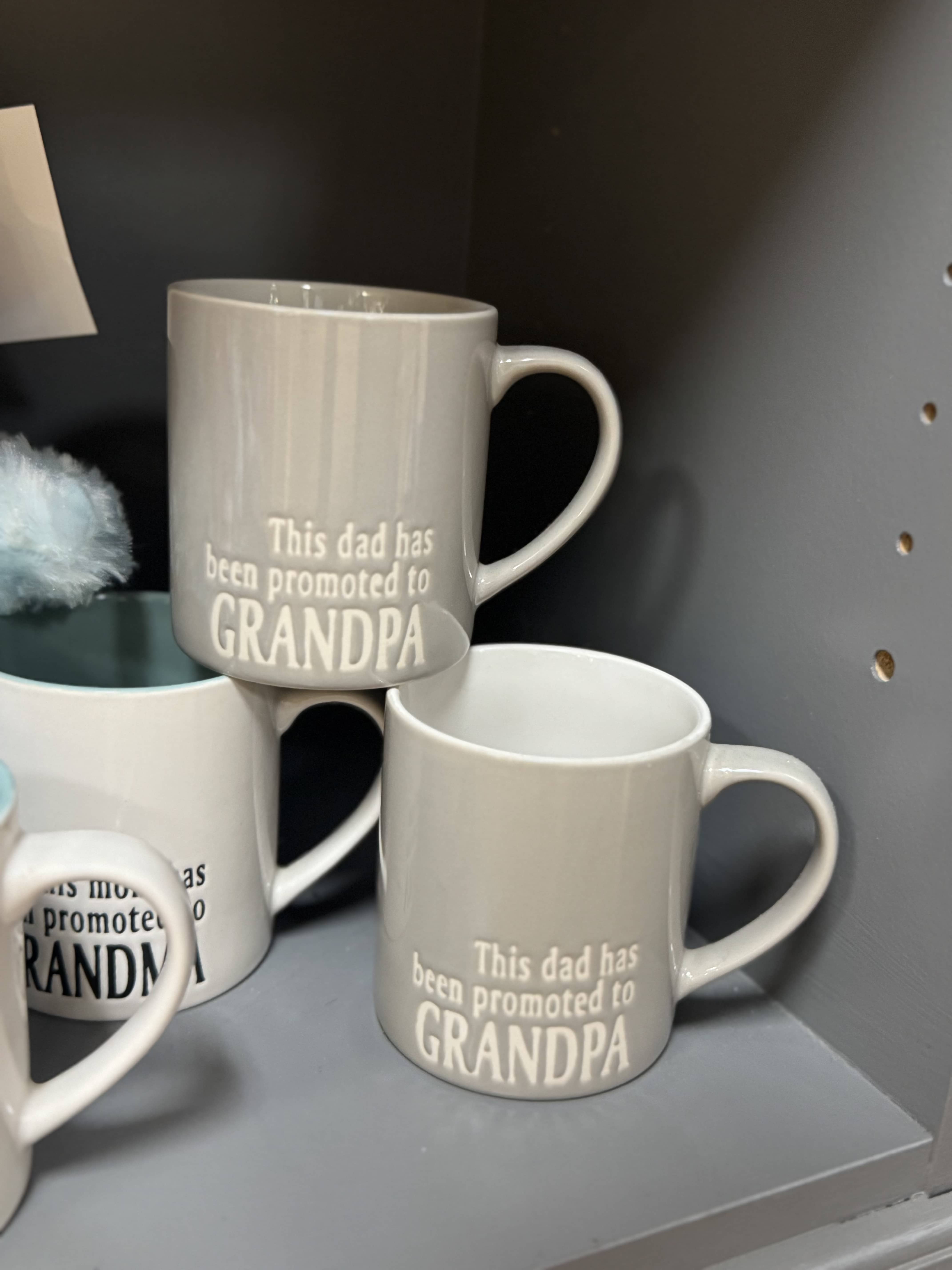 Gray ceramic mugs with the text "This dad has been promoted to GRANDPA"