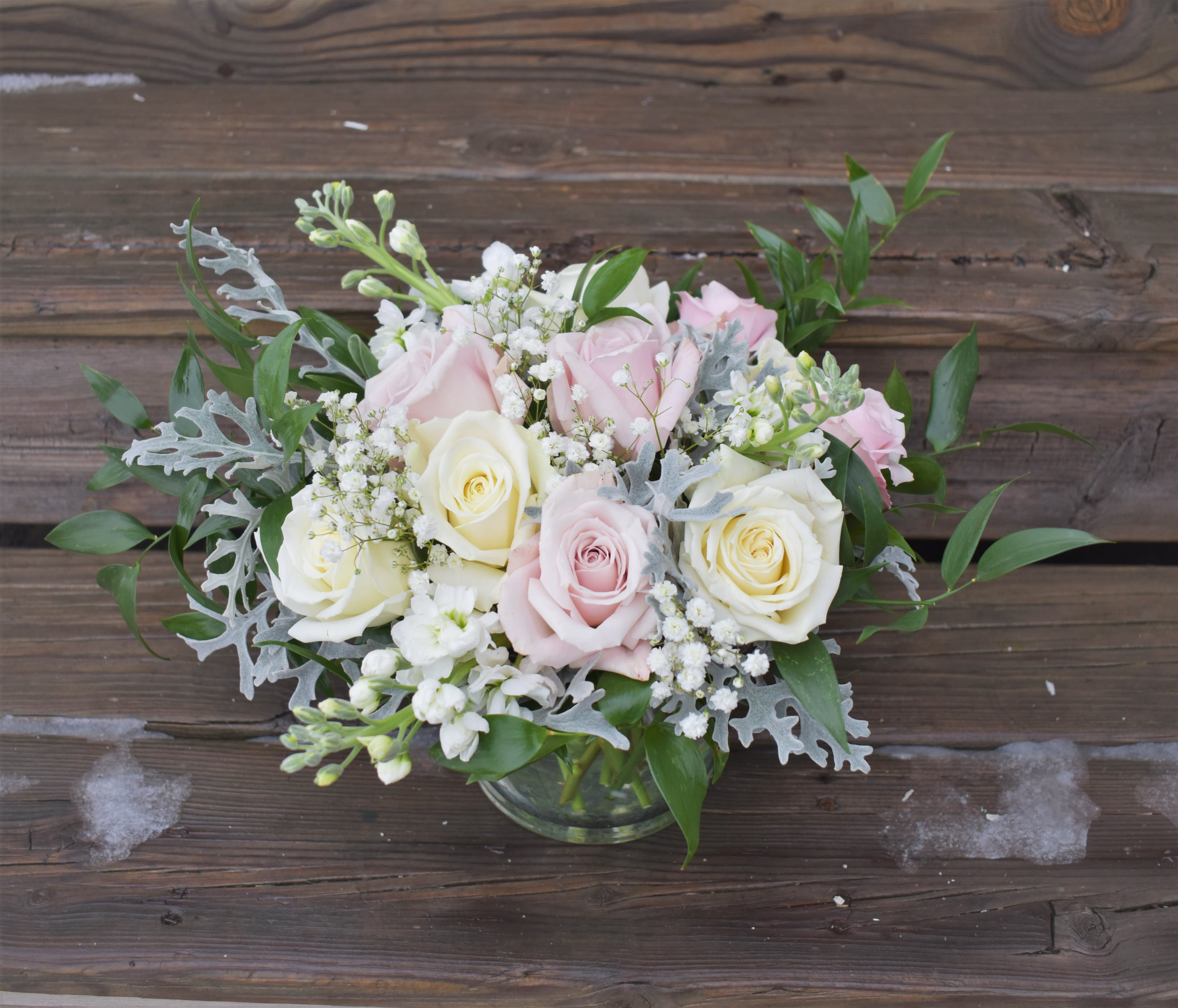 Pink and white roses arranged in a glass vase
