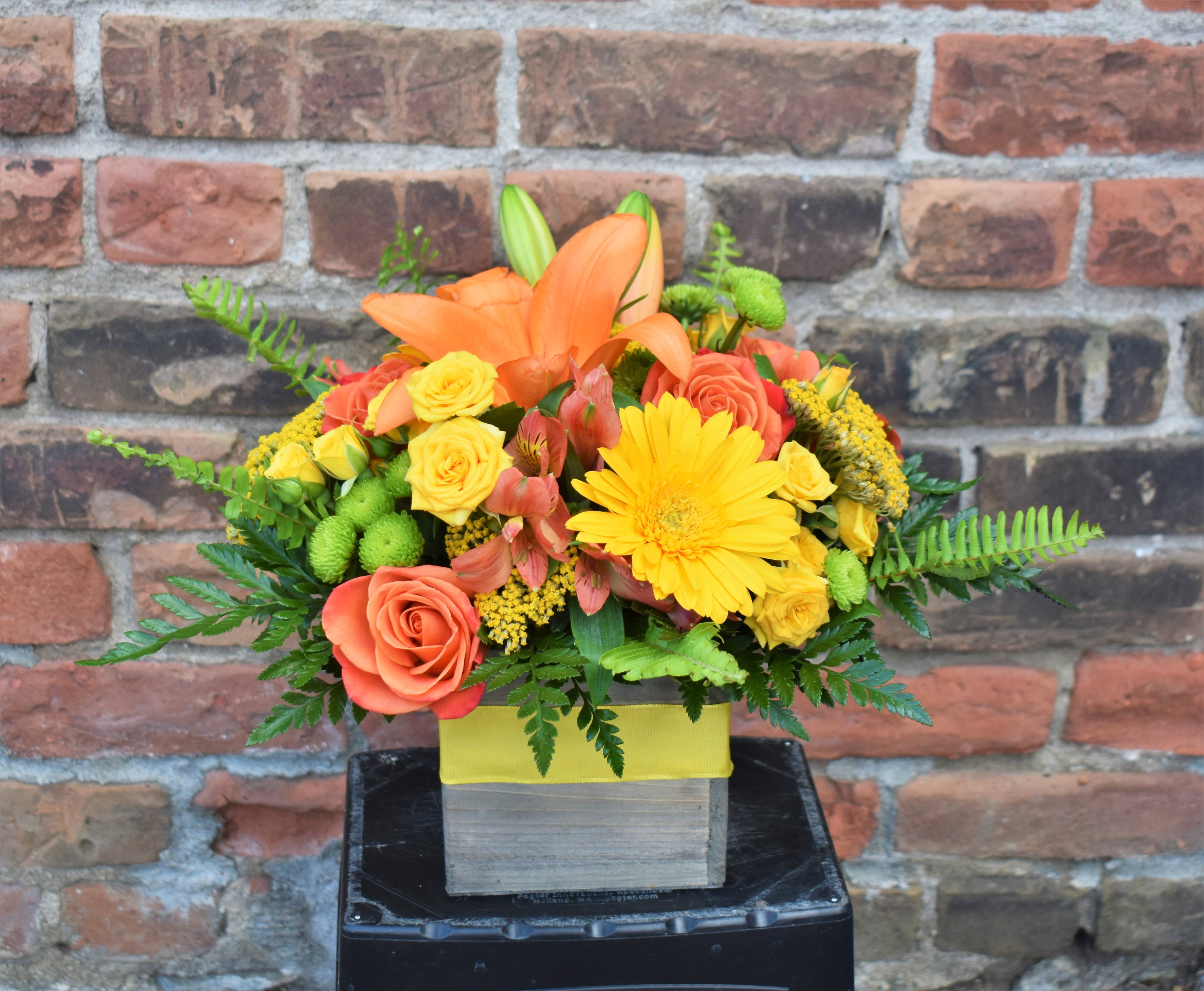 Orange lilies and yellow roses in a square box arrangement